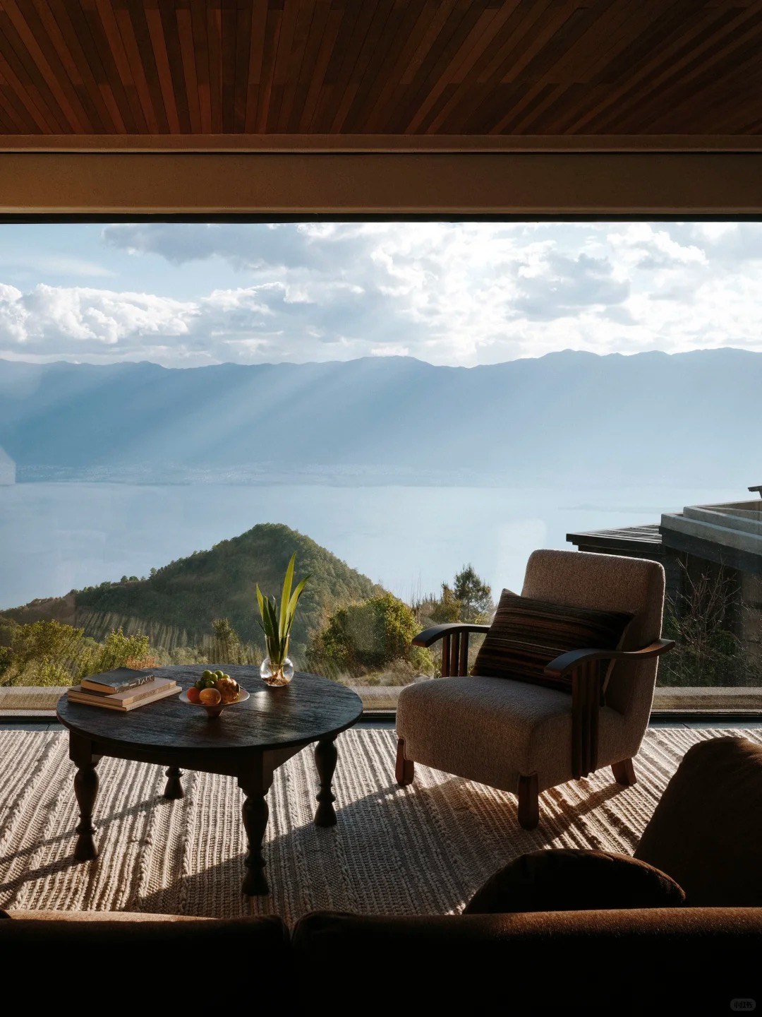Muxi Dali Huoshan Hotel on the summit of Huoshan Mountain — crimson accents against raw stone with floor-to-ceiling views over Erhai and Cangshan