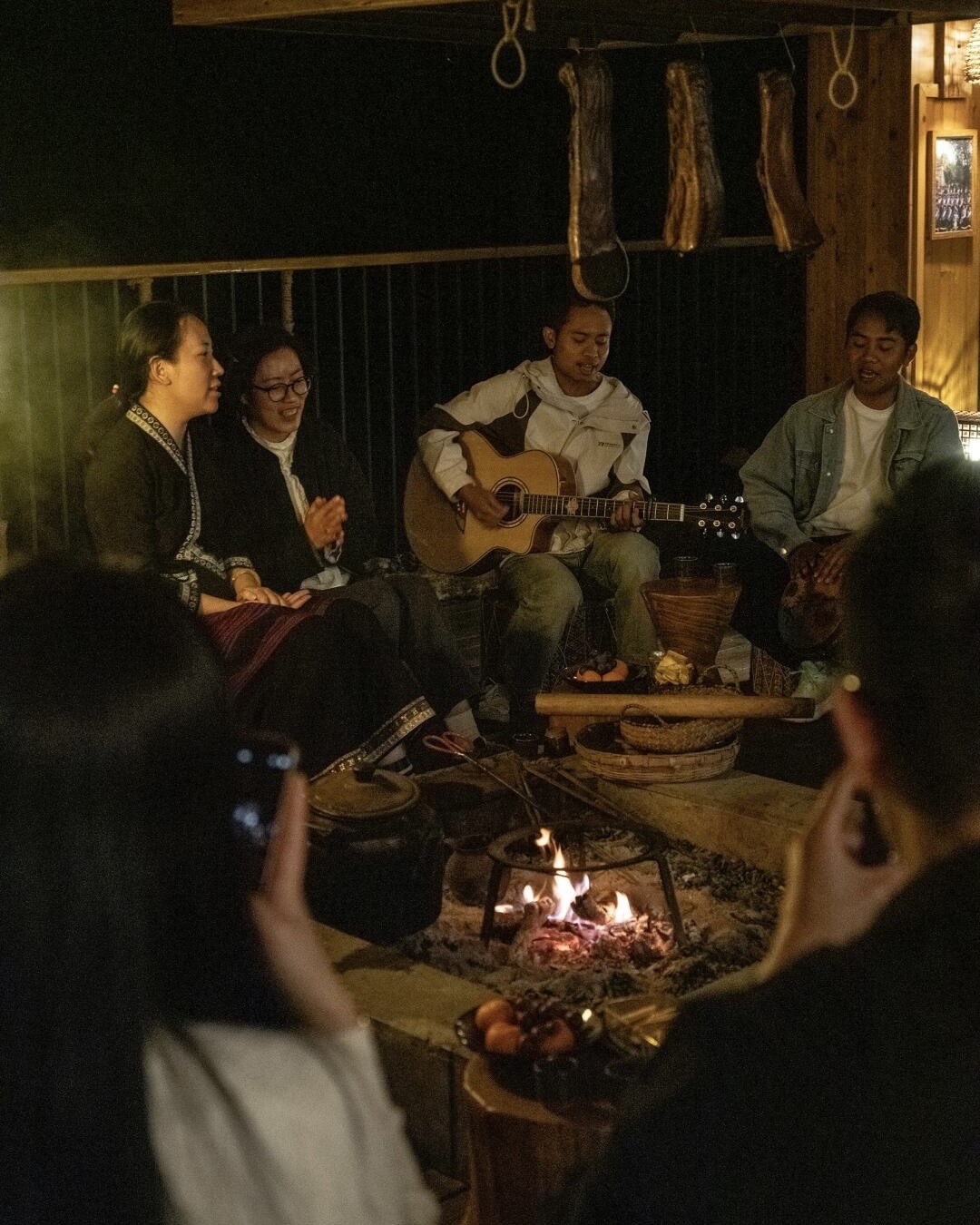 Evening fire pit gathering with guitar at a Jingmai Mountain lodge