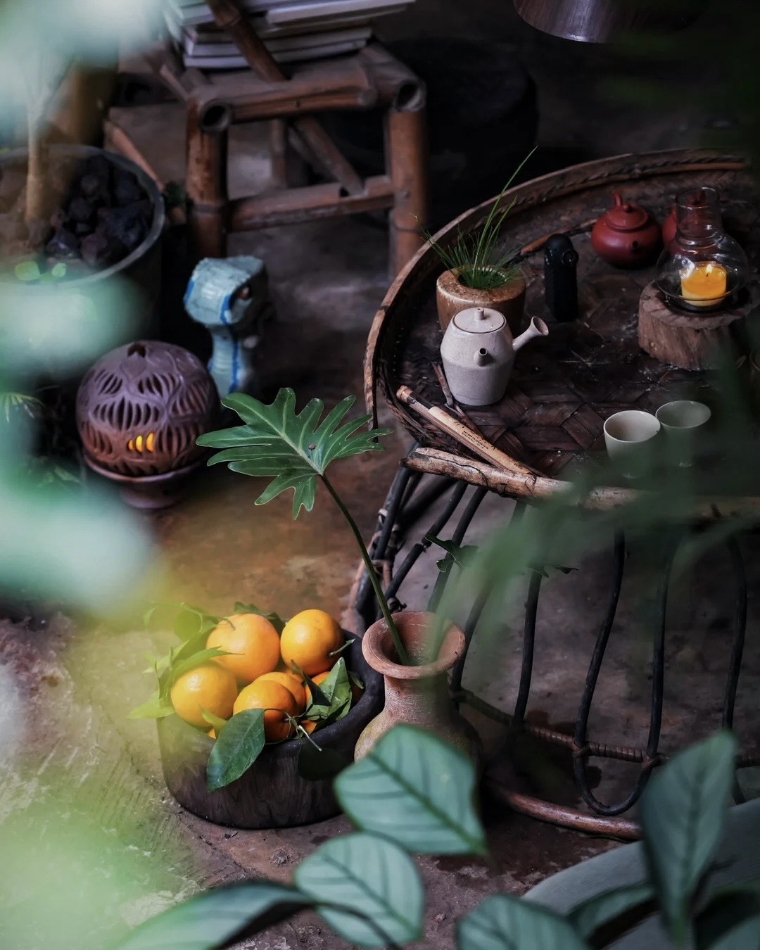 Rustic tea table set with oranges and candlelight in a Jingmai Mountain tea house