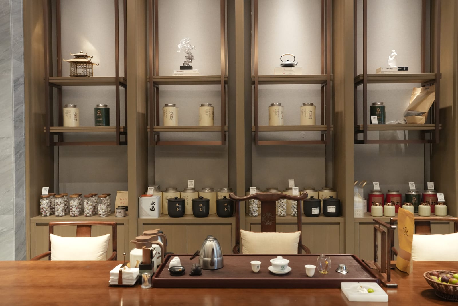 Elegant Bingdao tea-tasting room with 冰岛 Pu'er canisters on timber shelves and a gaiwan tea service on the table