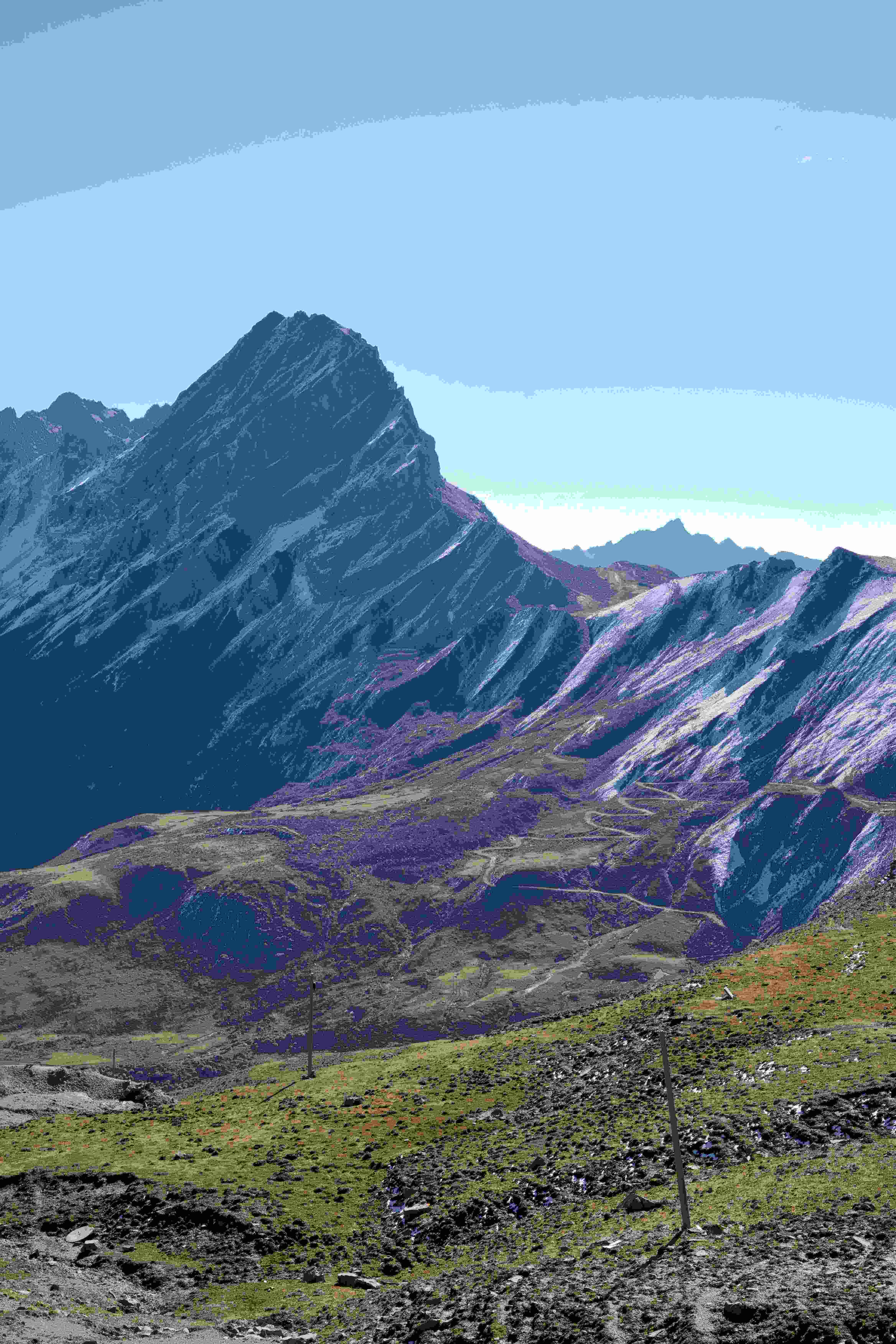 Sharp alpine peak rising above plateau grassland on the Li–Xiao Road approach to Siguniang