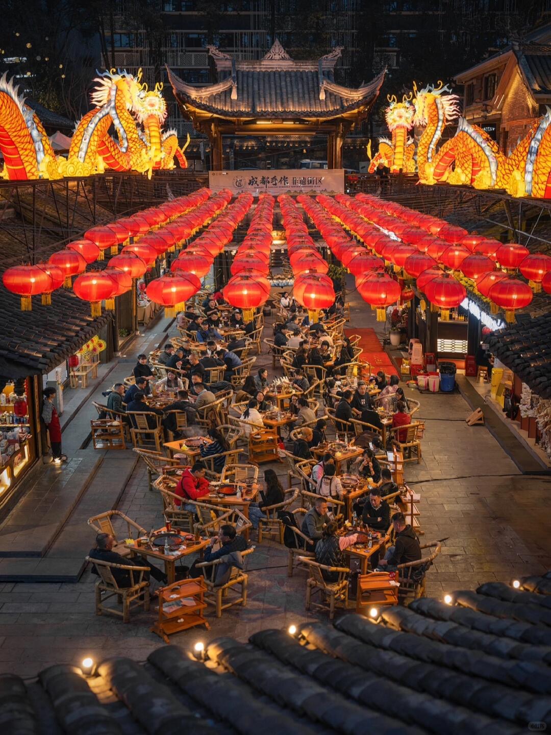 Red lanterns and golden dragons in a Jinli courtyard at night