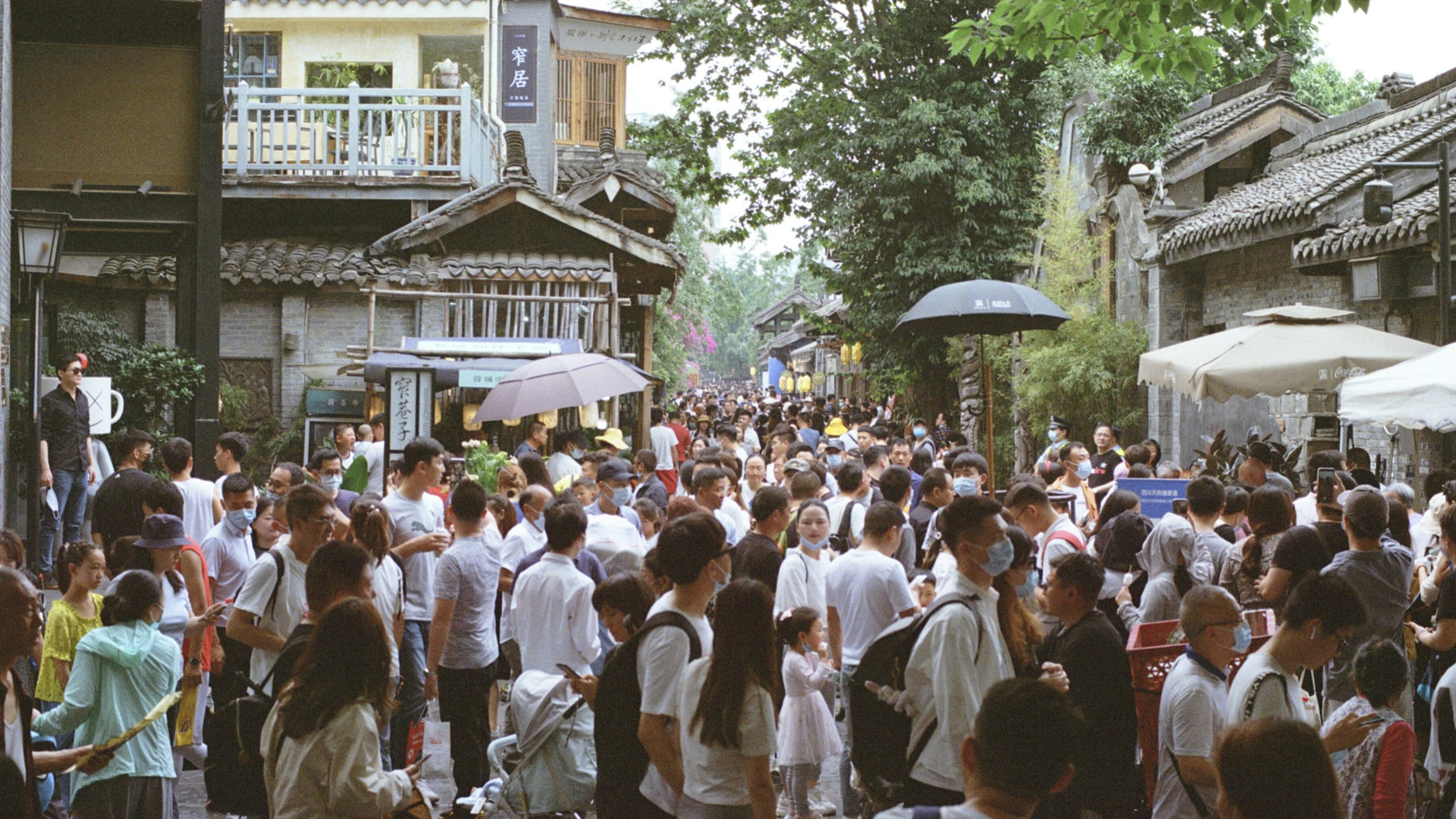 Kuanzhai Alley (宽窄巷子) in mid-afternoon — grey tiles, wooden shopfronts, the popular reality