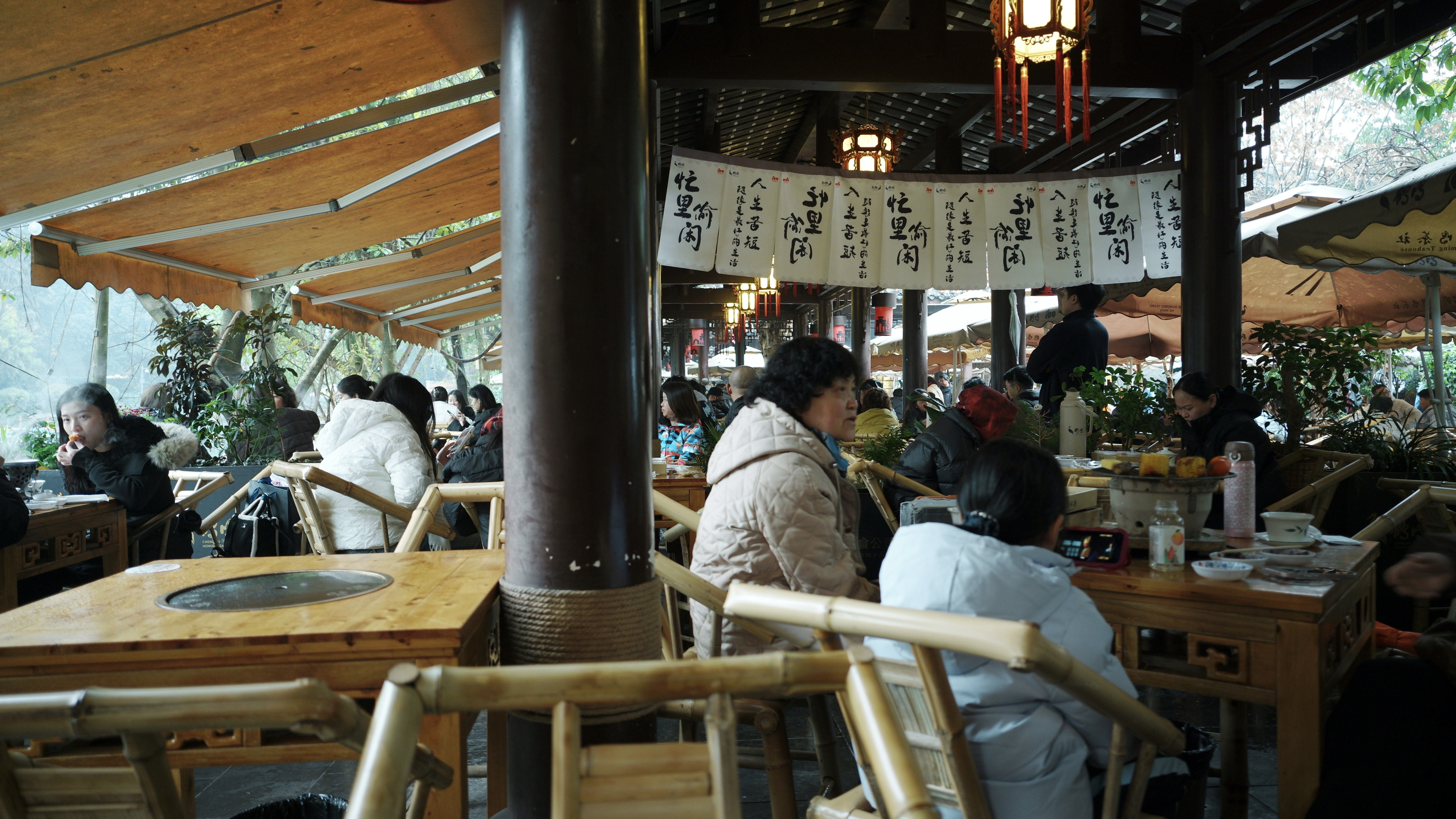 Outdoor bamboo-chair teahouse with regulars in padded jackets — the Chengdu daily ritual