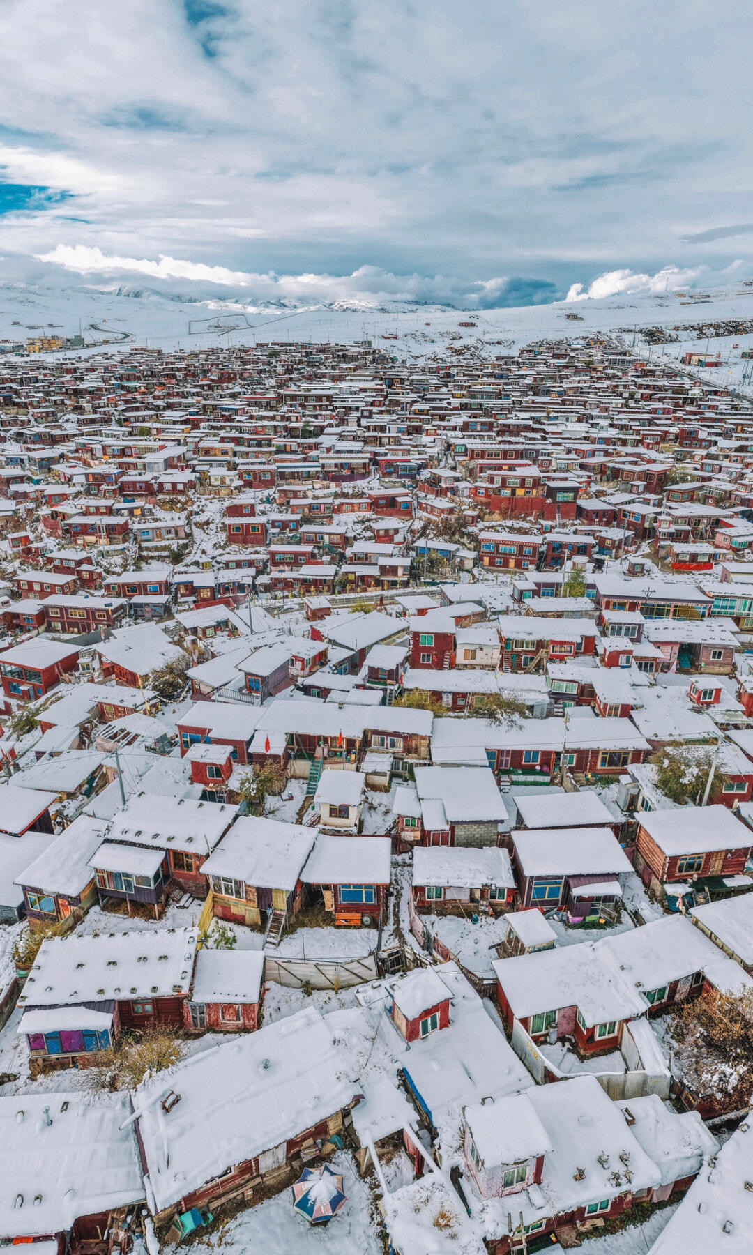 Aerial over Yaqing Gar — the red-roof nunnery island in the Chuqu river, Baiyu county