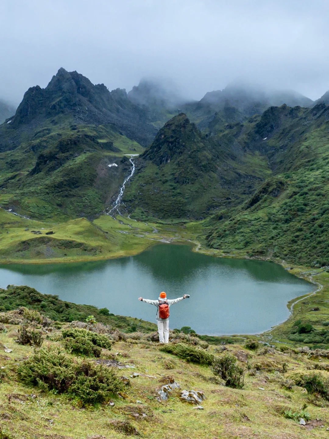 Black Sea — the alpine tarn at 4,100 m ringed by rocky peaks, with a hiker on the rim