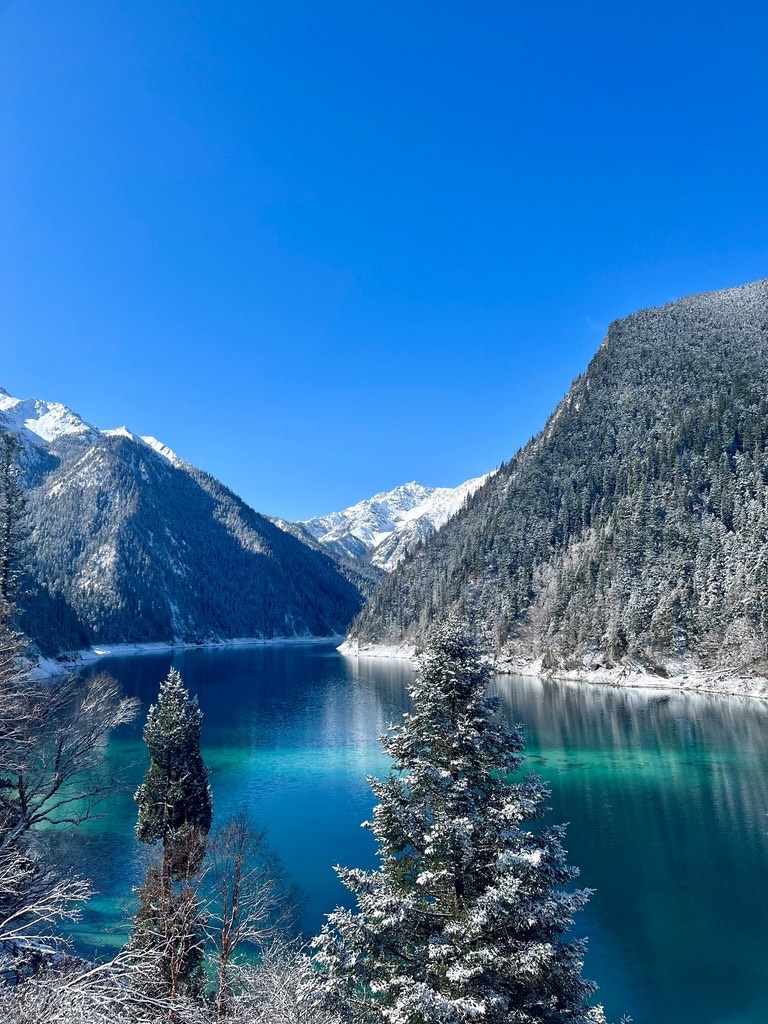 Long Lake in winter — vivid blue lake between snow-dusted evergreen slopes and mountain ridges
