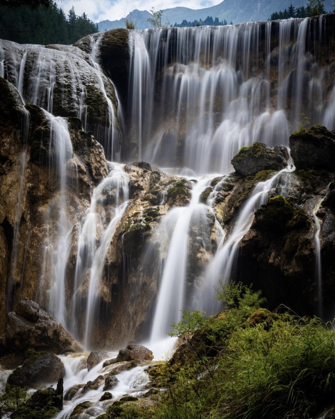 Pearl Shoal Waterfall in Jiuzhai Valley's Rize Valley — a wide multi-level cascade over calcium travertine in summer