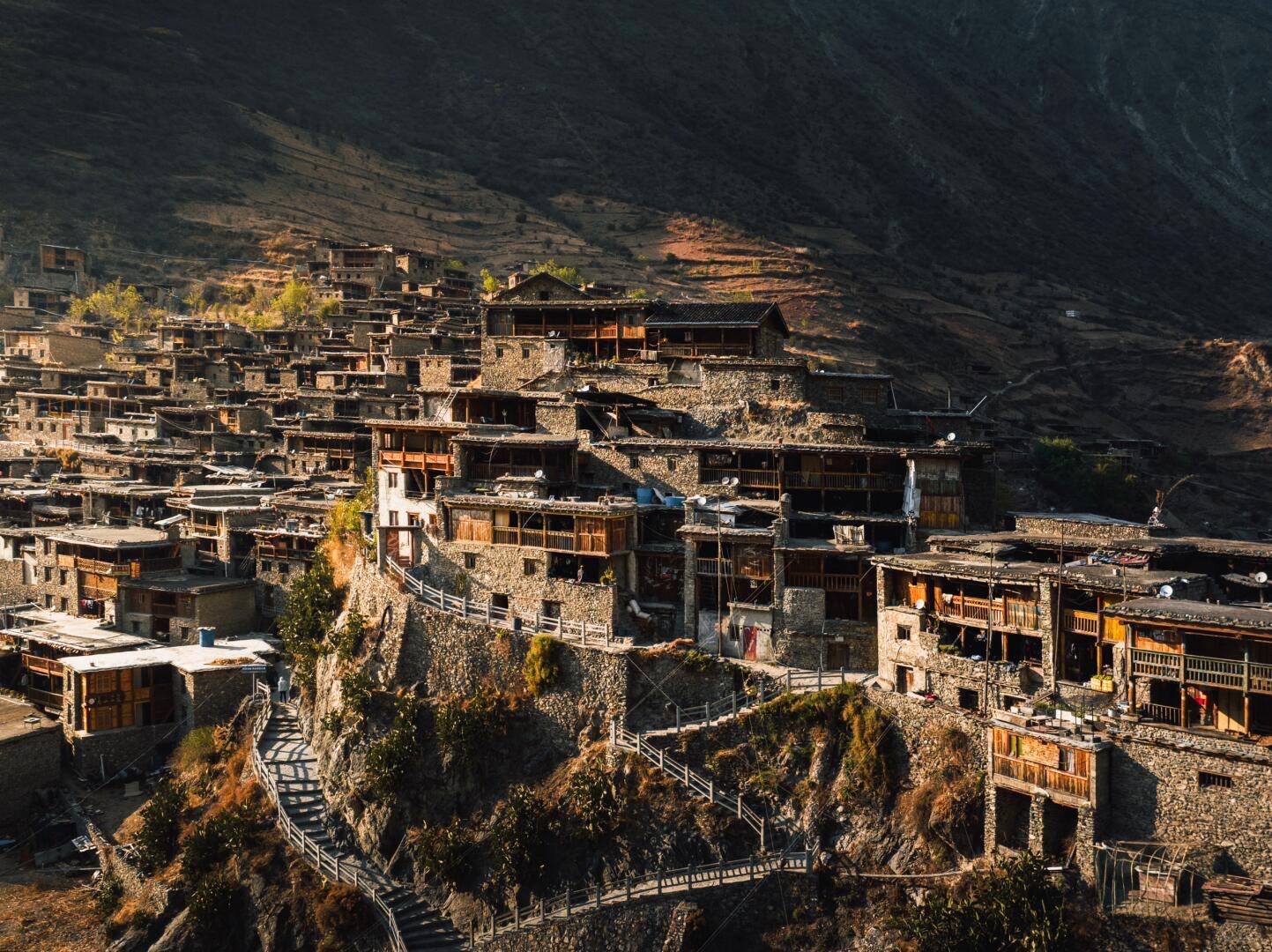 Remote Naxi mountain village of stone-and-timber houses on a cliffside ridge