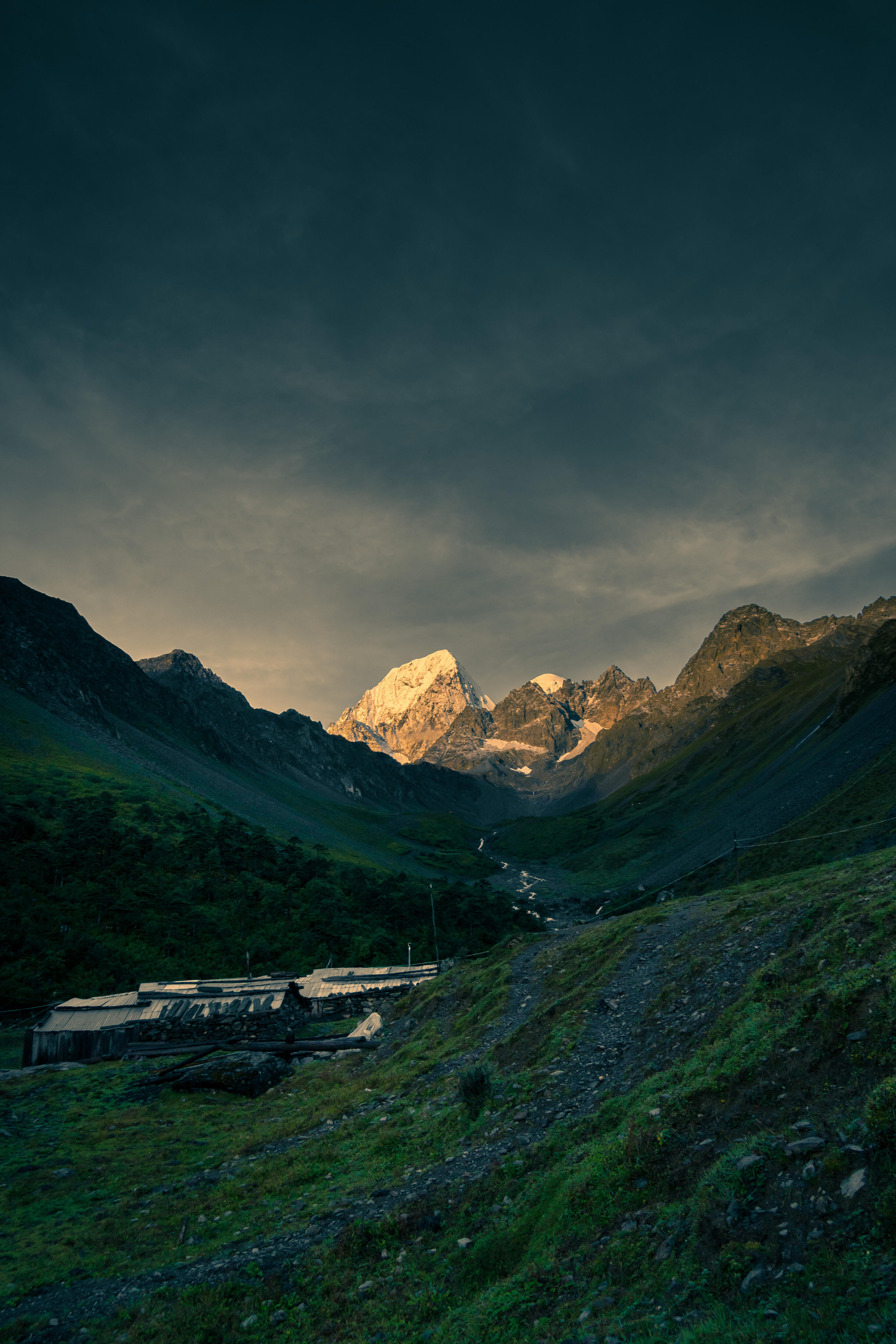 Remote campsite at sunset with the peak glowing gold — Pojun Camp evening light
