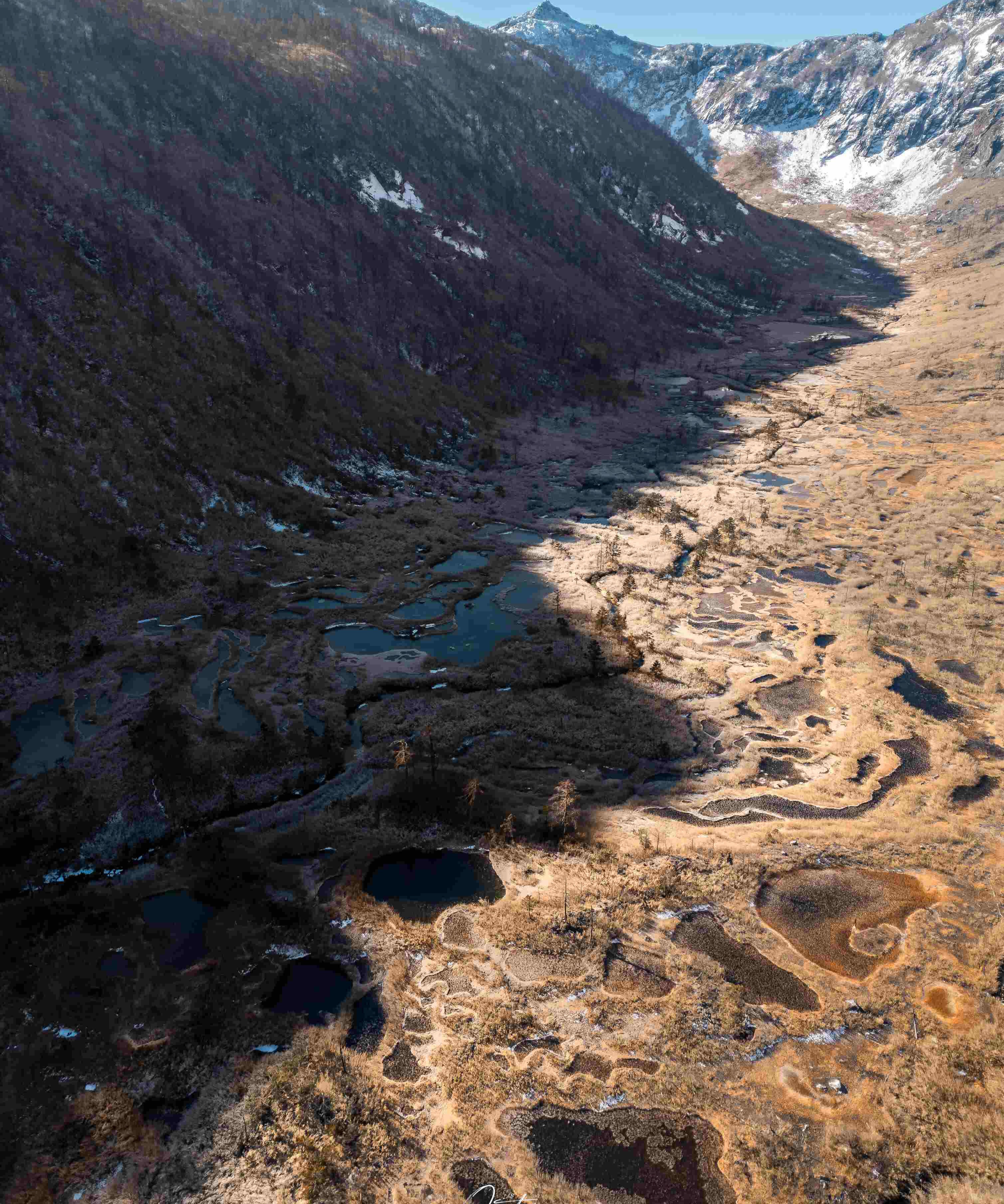 Aerial of cascading alpine limestone pools high above the Nujiang canyon
