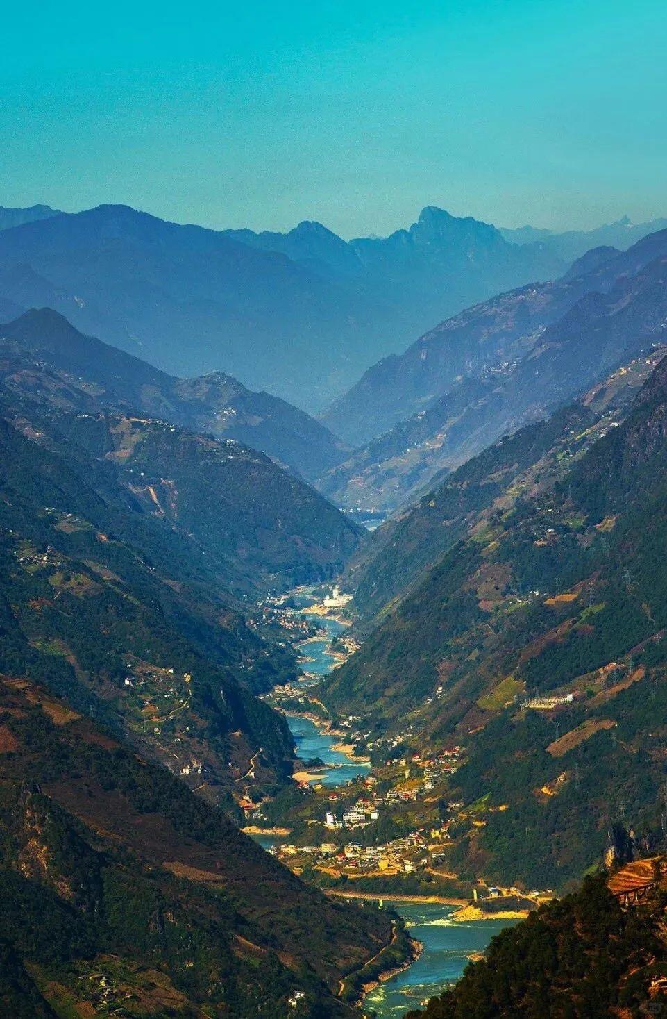 Dusk golden hour over Nujiang's layered ridgelines and deep shadowed valleys