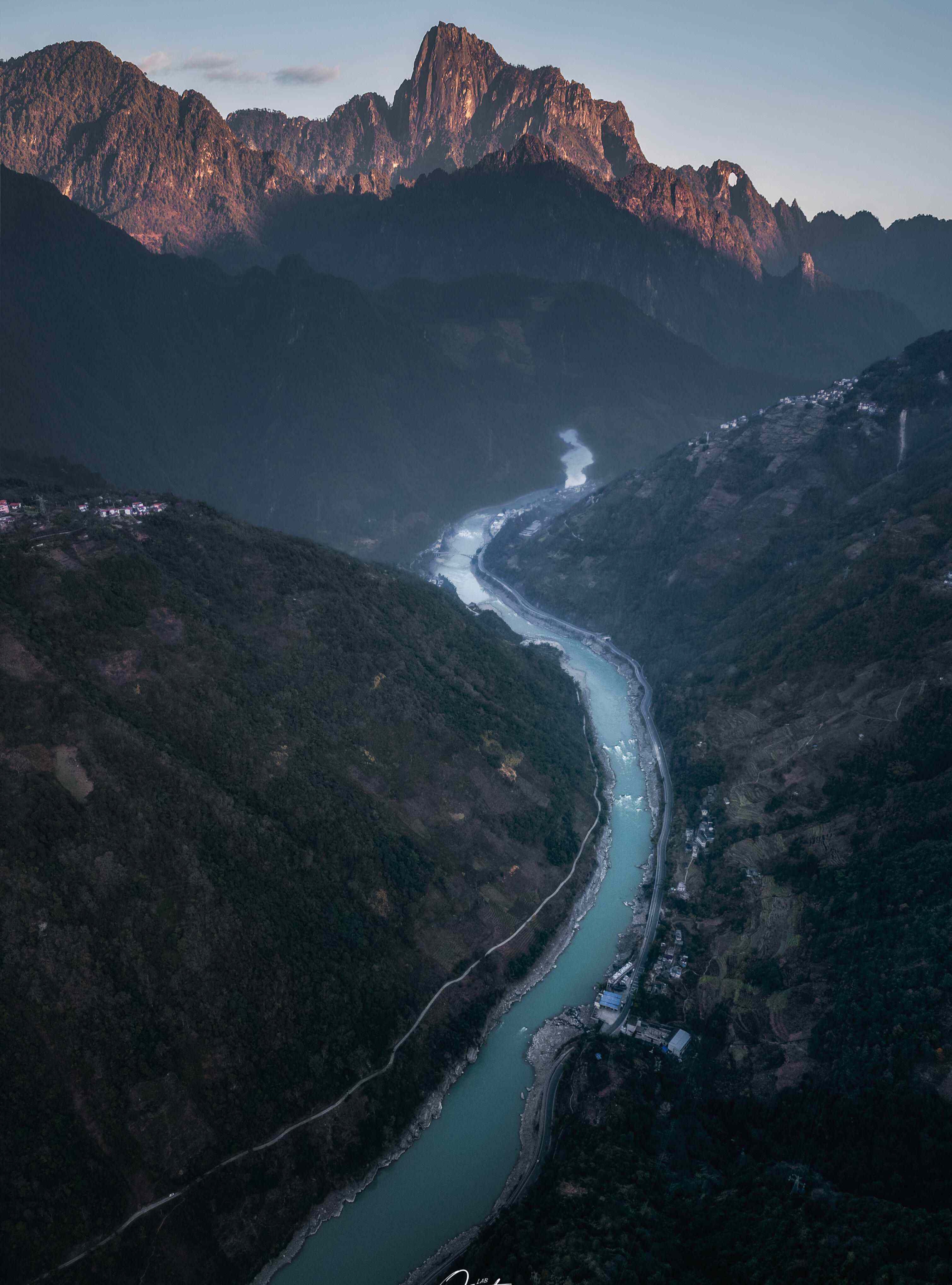 Sunrise on a jagged Nujiang peak high above the turquoise Salween winding through the gorge