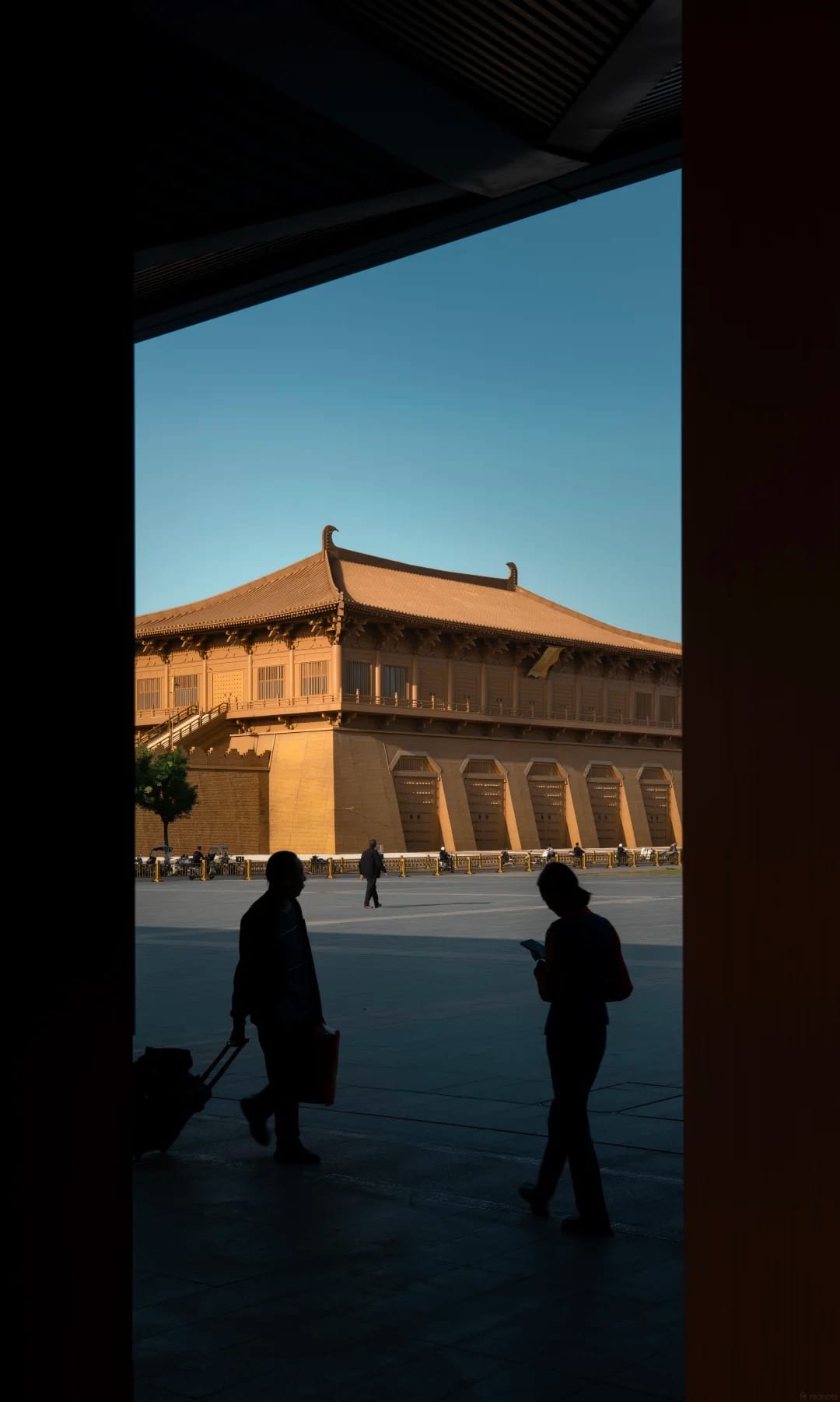 The Shaanxi History Museum's Tang-style hall framed by a dark doorway, two figures in silhouette
