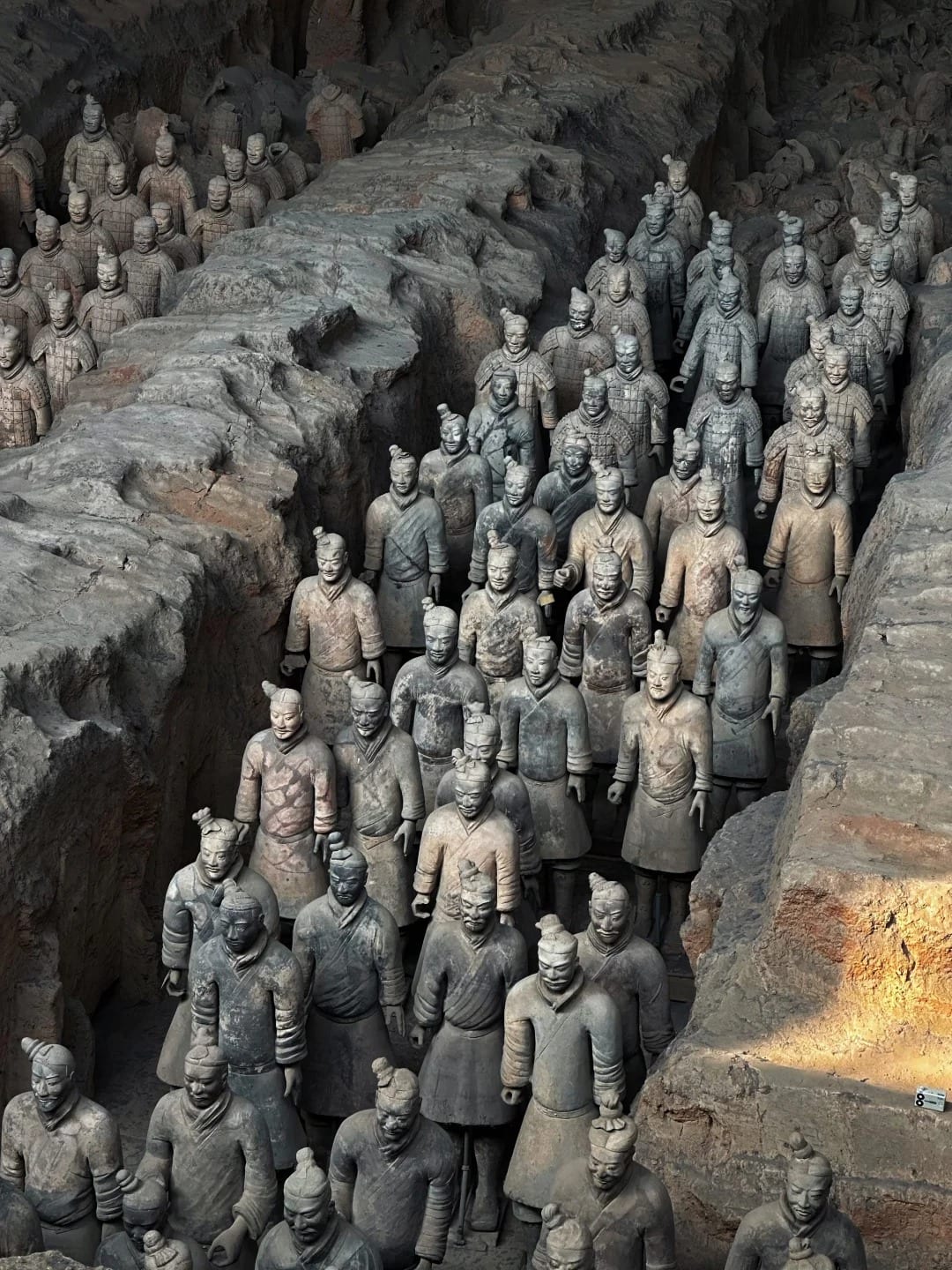 Rows of terracotta warriors standing in the earth corridors of Pit 1, Xi'an