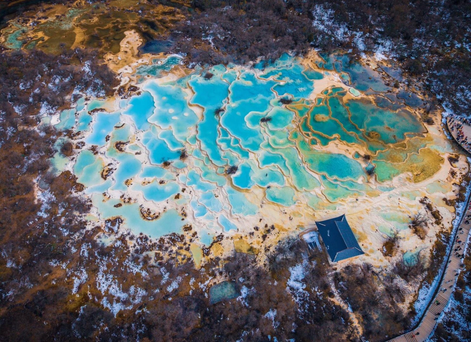 Huanglong's Five Color Pool gleaming with vivid mineral hues on a clear day
