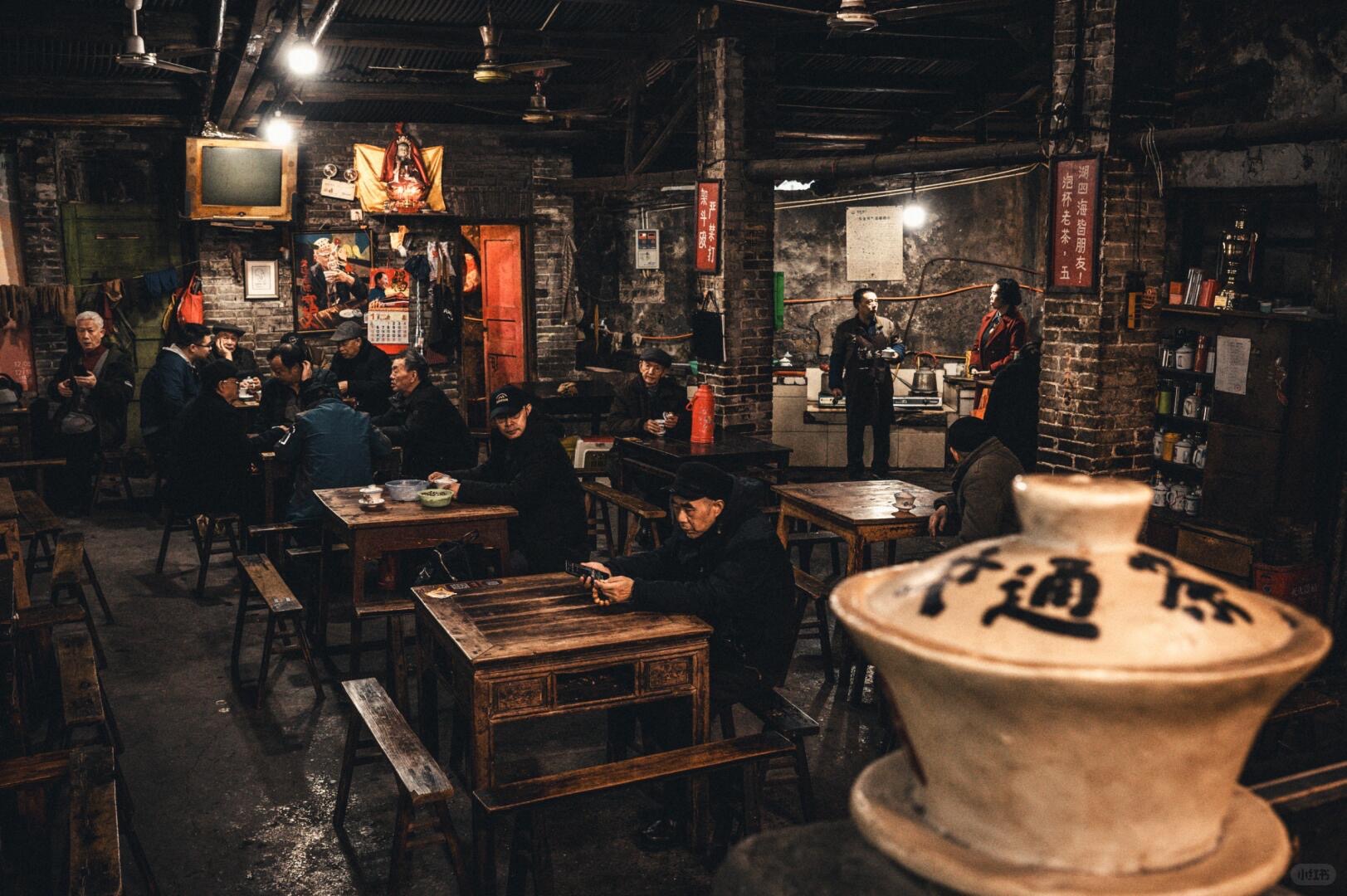 Locals at wooden tables inside a working Chaotianmen traffic teahouse — the last slow cup before the airport transfer
