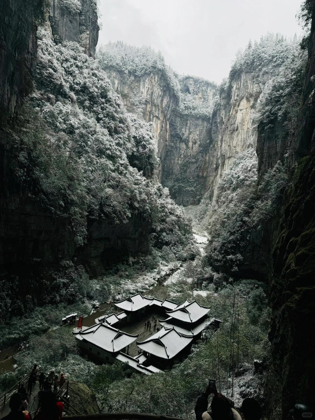 Wulong's Three Natural Bridges — limestone arches towering over a small valley floor, snow-dusted in winter light