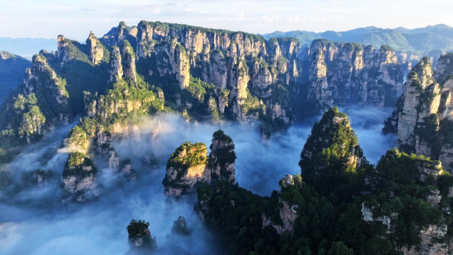 Sandstone pillars at Wulingyuan rising through a valley of cloud, Zhangjiajie — hero image for the Classic China: Warriors, Pandas & Stone Pillars tour by Boutique China