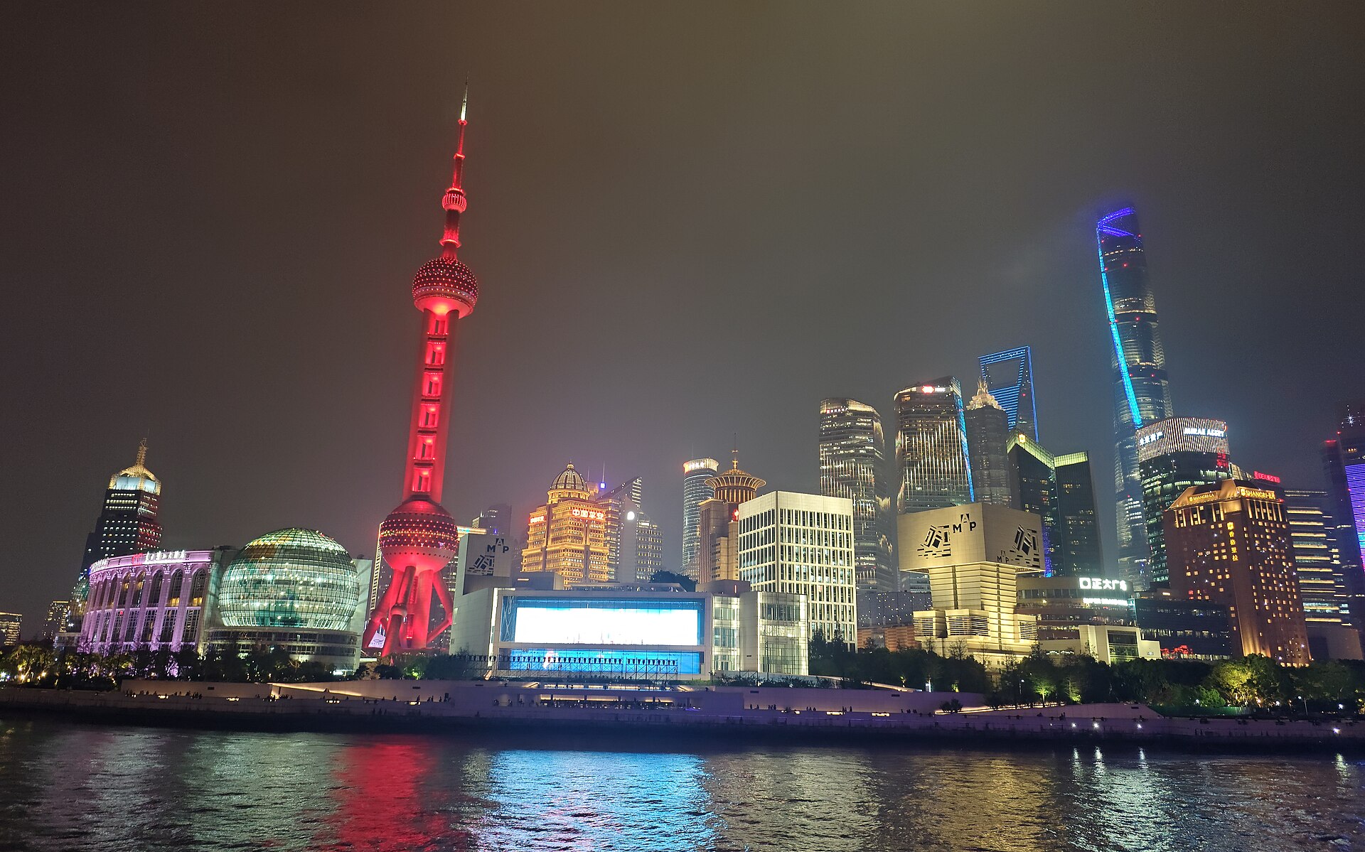 Pudong's illuminated skyline reflected in the Huangpu River at night, seen from the Bund, Shanghai — Classic China tour