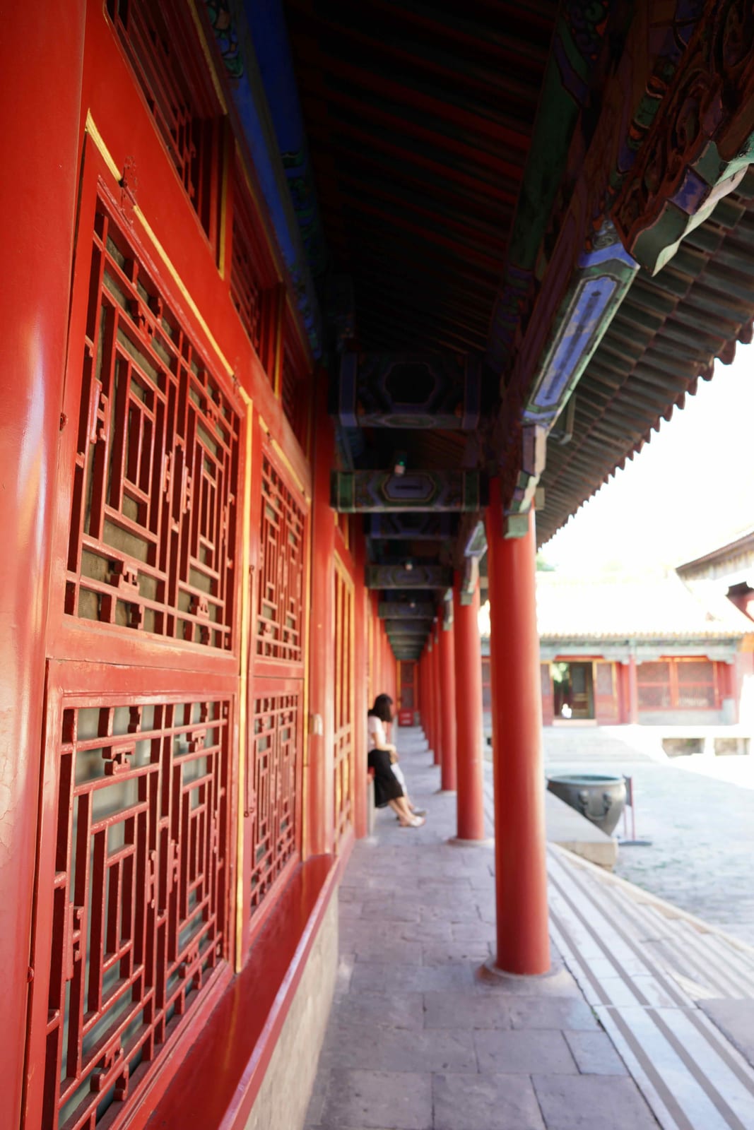 A red-lacquered gallery of lattice doors and columns inside the Forbidden City, Beijing — Classic China & Yunnan tour