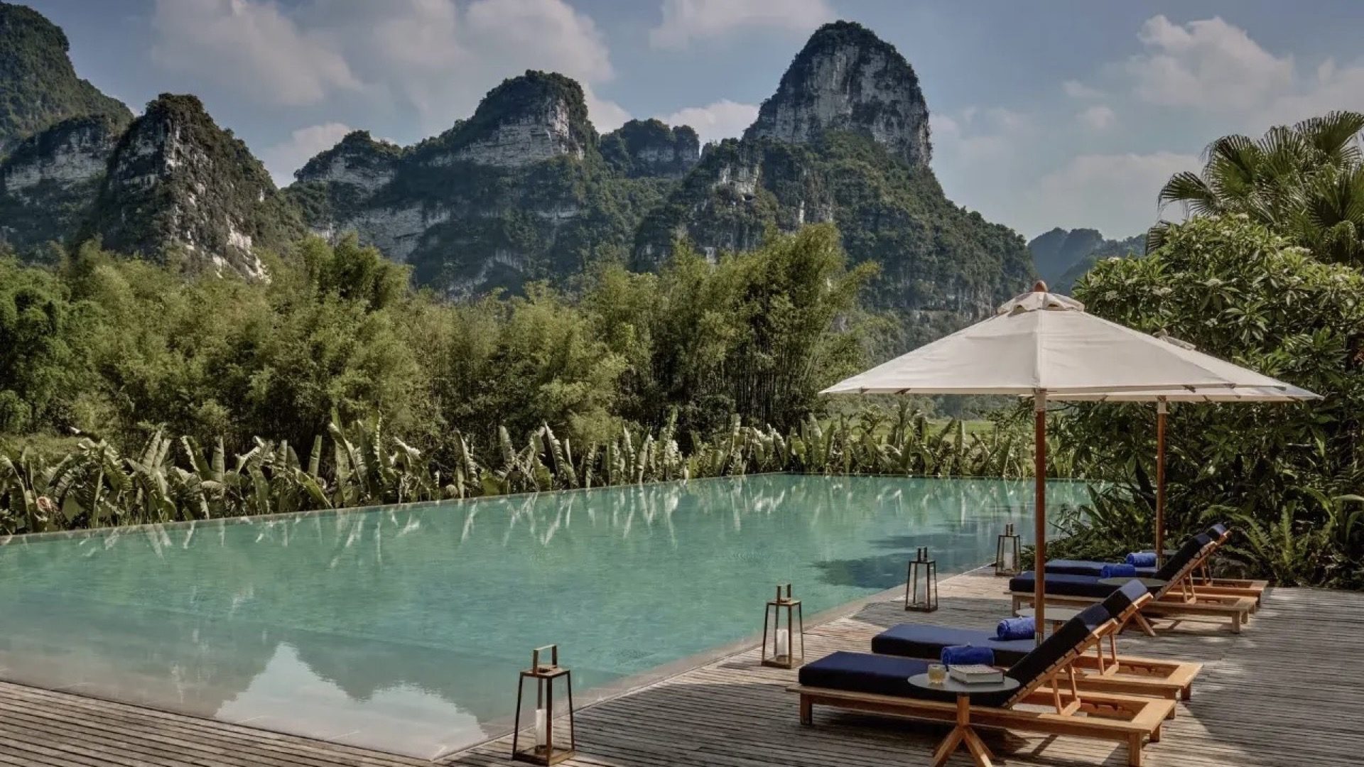 Infinity pool at a Yangshuo boutique resort with karst peaks reflected in the still water