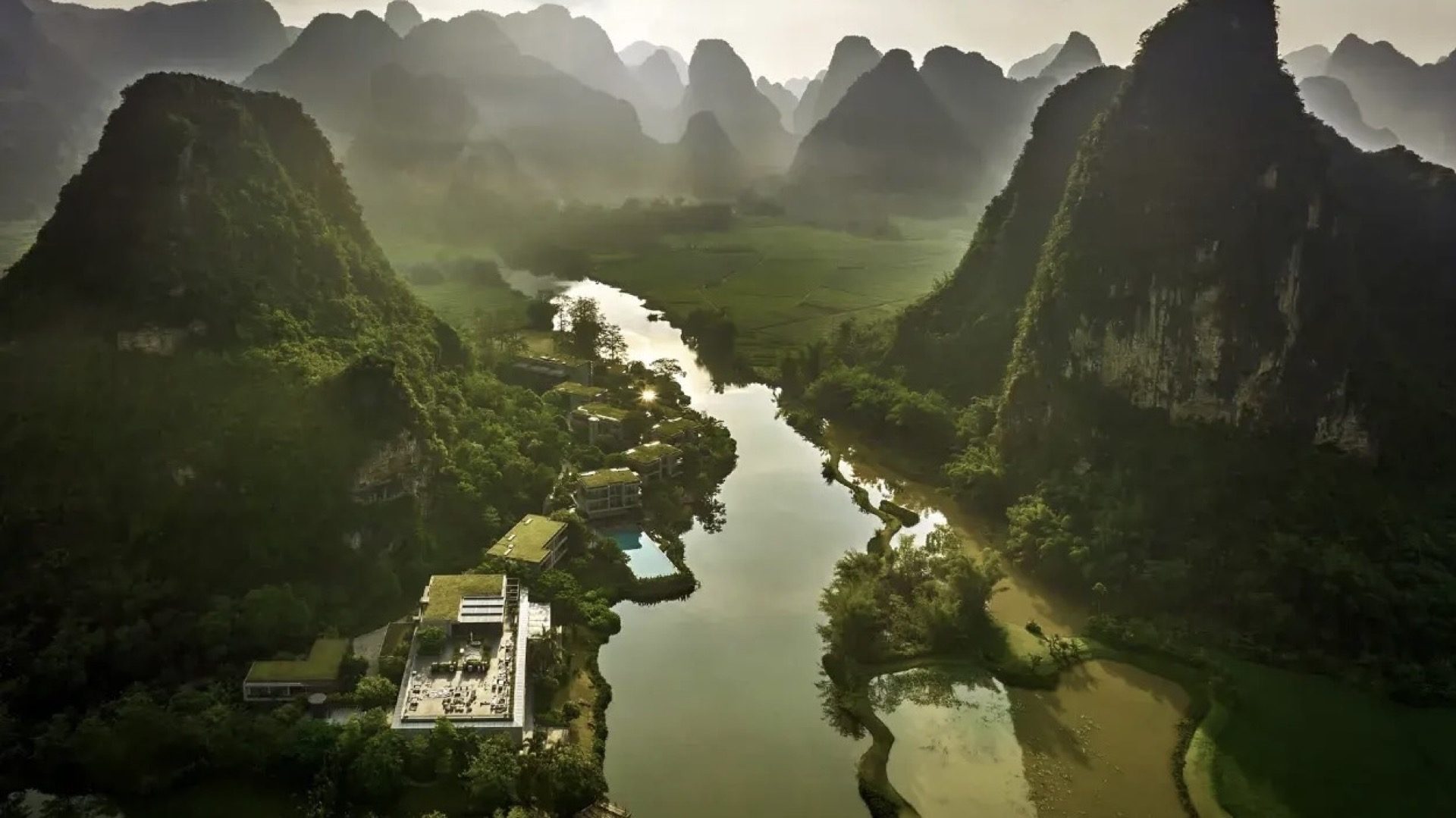 Aerial view of a Yangshuo boutique resort beside the river with karst peaks all around — Guilin private tour