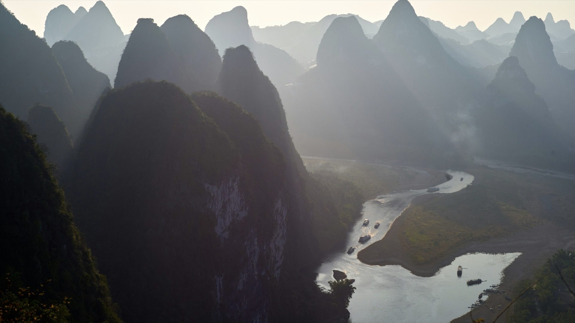Misty morning sunbeams filtering through karst peaks above the Li River, Guilin — Guilin private tour