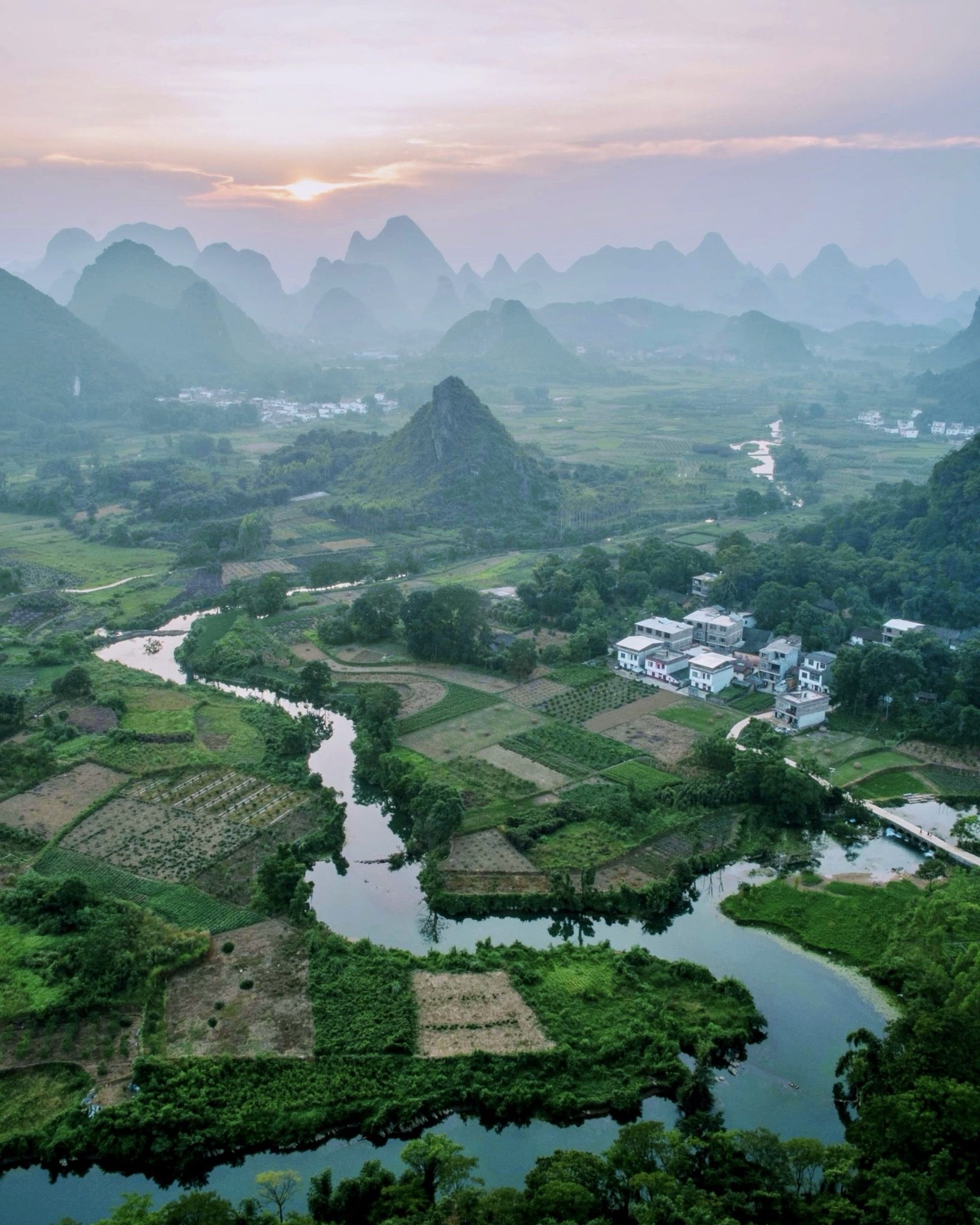 Rural karst countryside at dusk with rice fields and limestone peaks, Guilin — Guilin private tour
