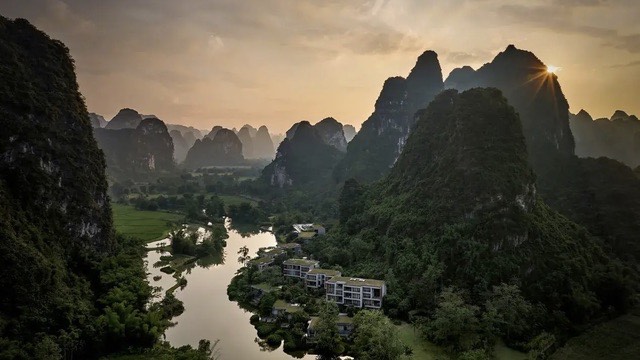 Golden-hour light over Yangshuo's karst peaks and the Li River from a hillside lodge