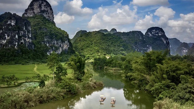 Bamboo rafts drifting the Yulong River beneath Yangshuo's karst peaks