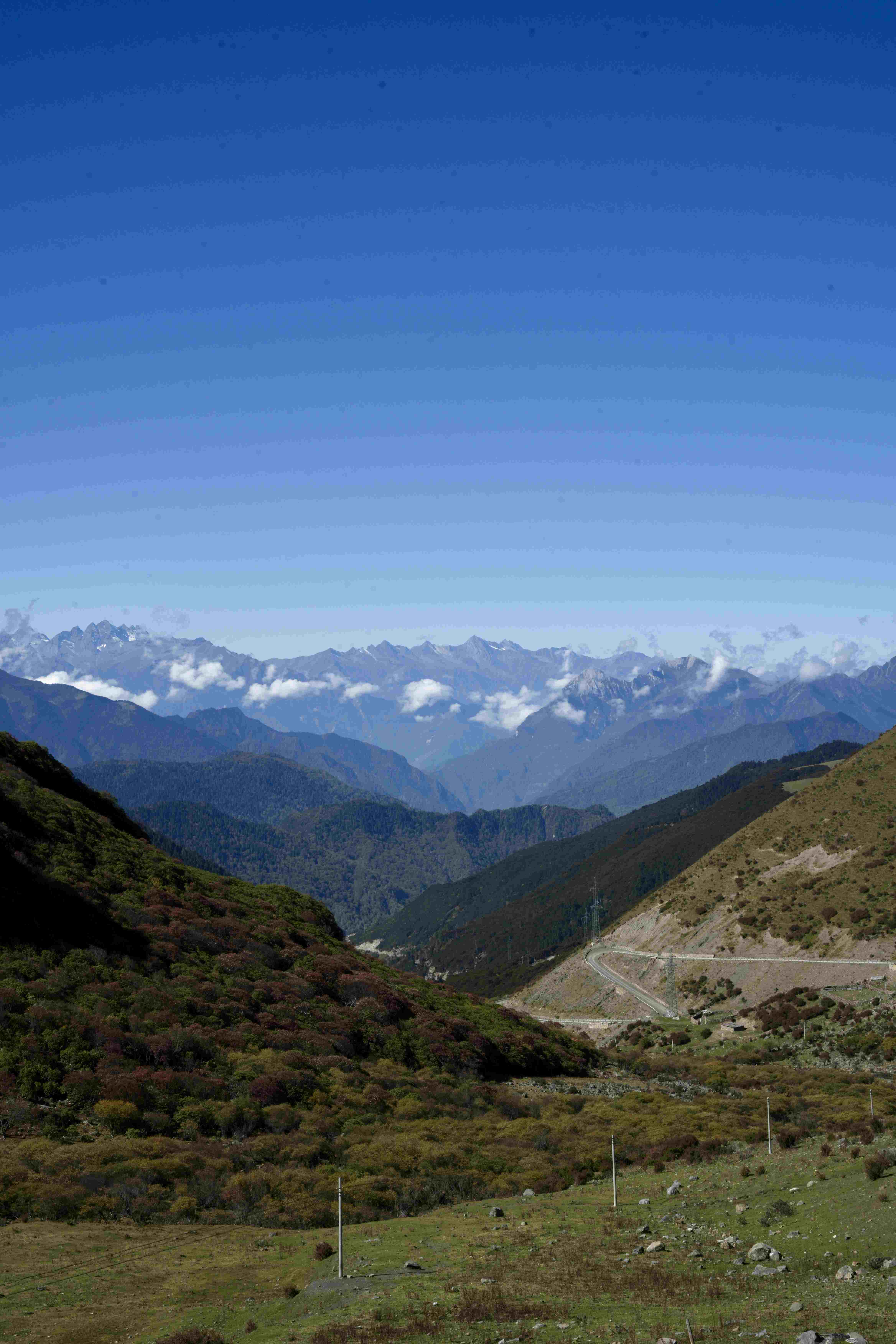 The G318 corridor winds through the Ganzi high country — the classic sky-road view from the Litang approach
