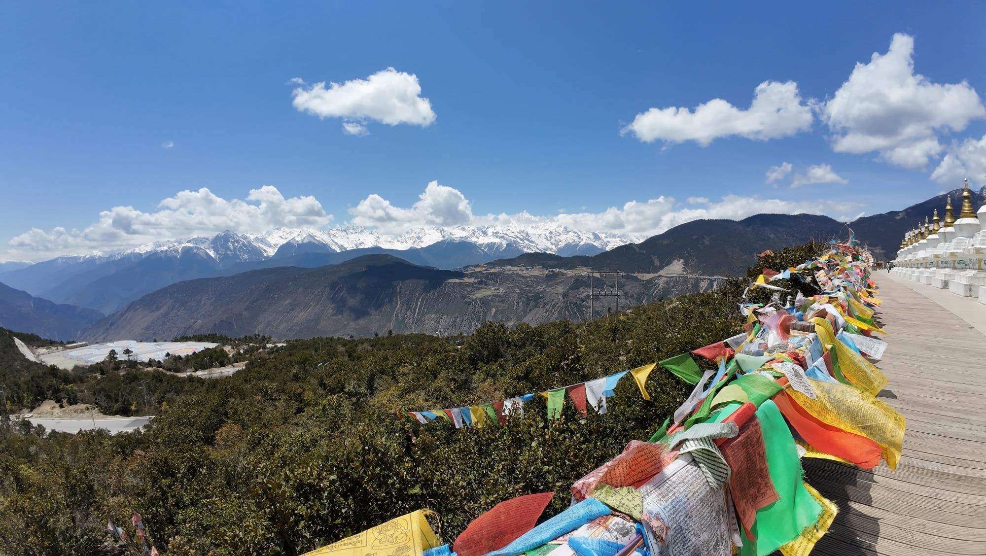 White stupas and prayer flags at Feilai Si with the Meili snow mountains behind — Shangri-La Wine Journey