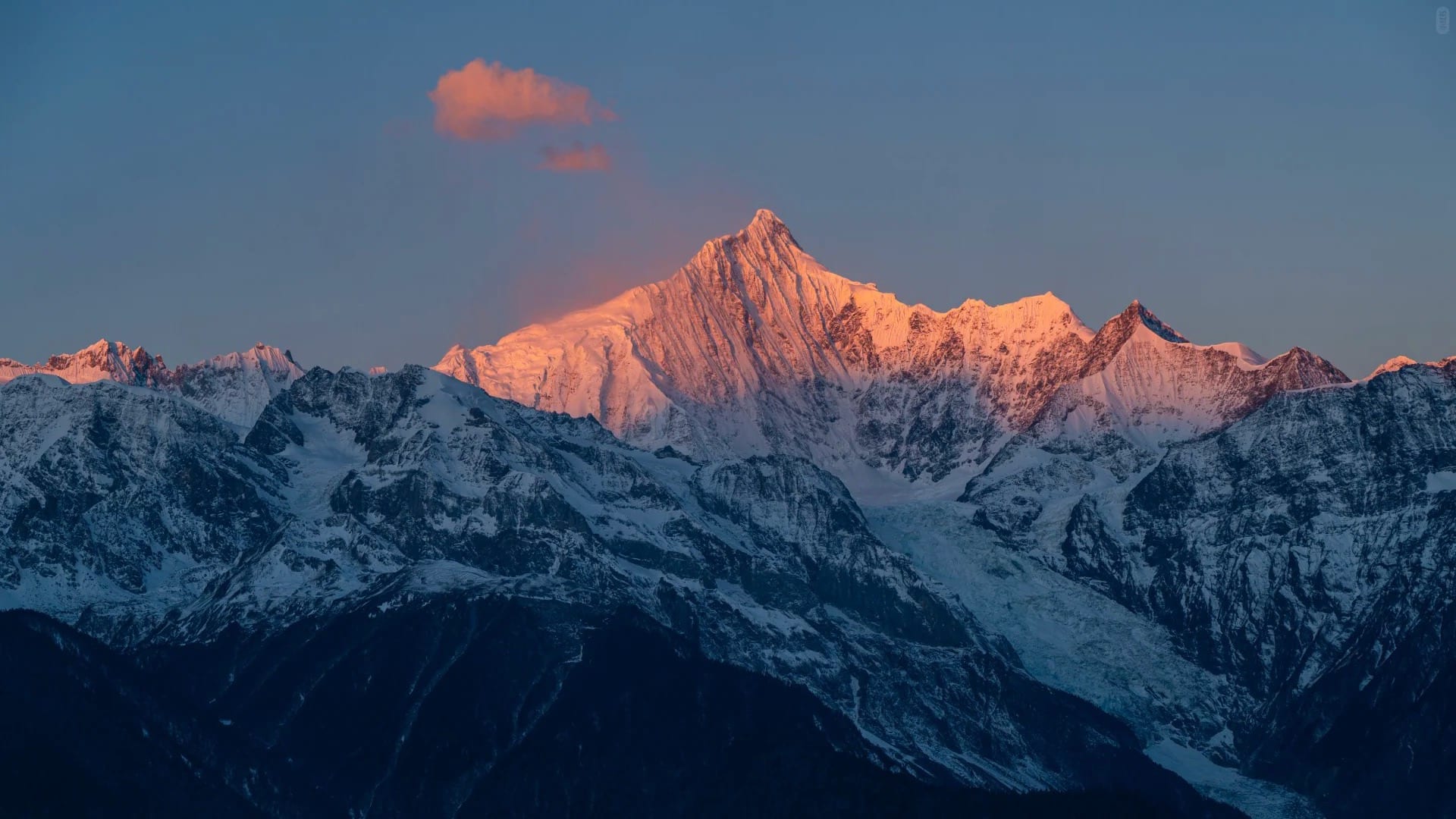 The first sun turning the snow of Kawagarbo gold above a dark ridge, seen from Feilai Si — Shangri-La Wine Journey