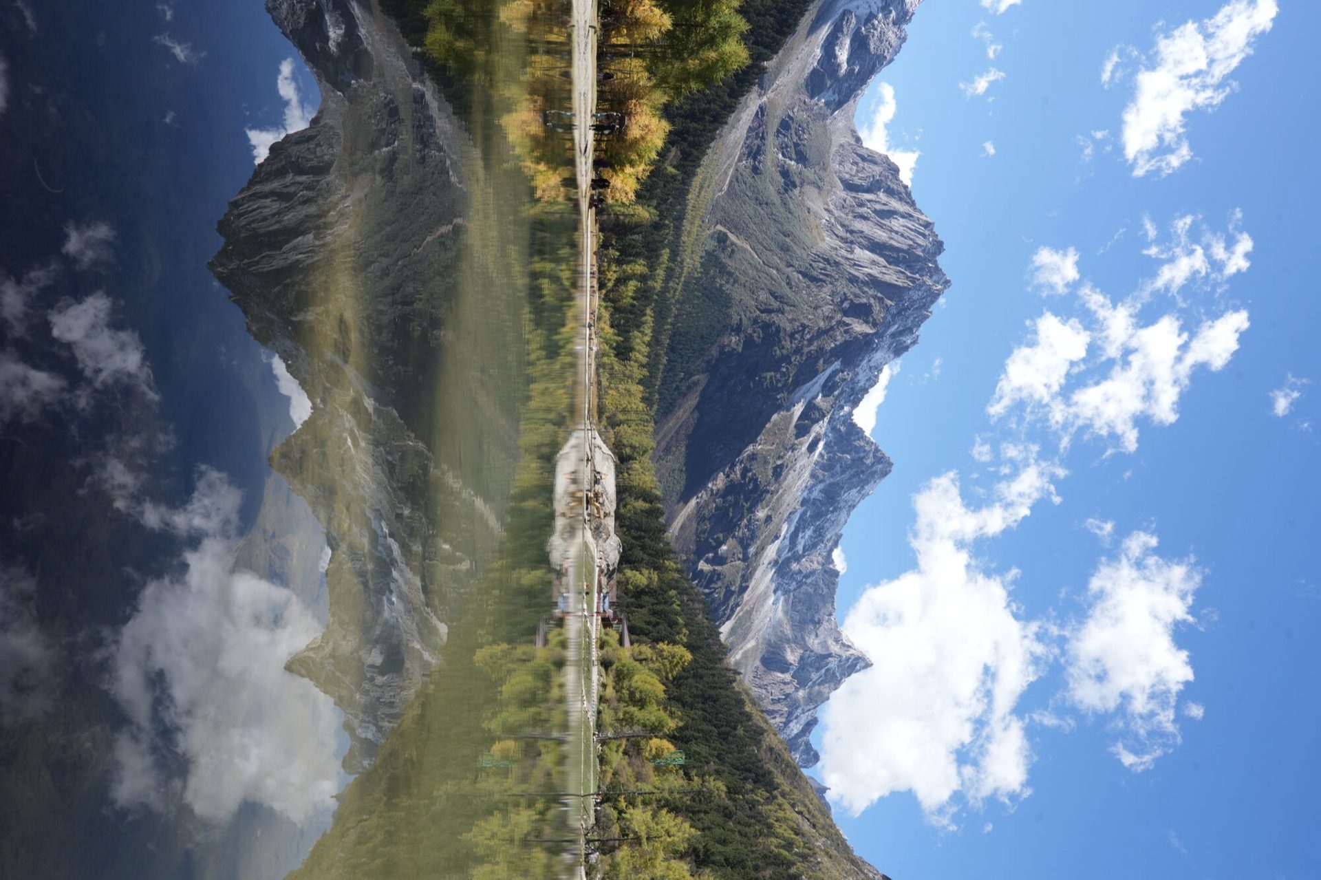 Wooden boardwalk along an emerald lake in Bipenggou Valley, West Sichuan