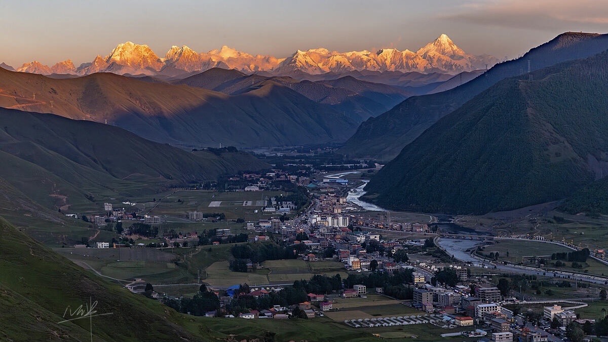 Alpenglow on Mount Gongga (7,556 m) glowing above the Xinduqiao valley at sunset