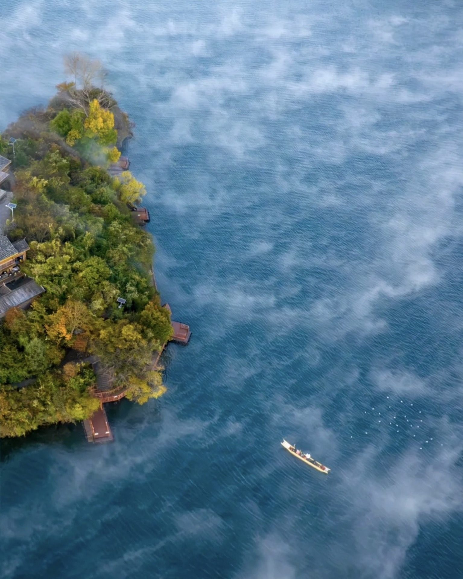 Lugu Lake's signature indigo-sapphire waters viewed from the Mosuo shoreline — a preview of Day 9's destination