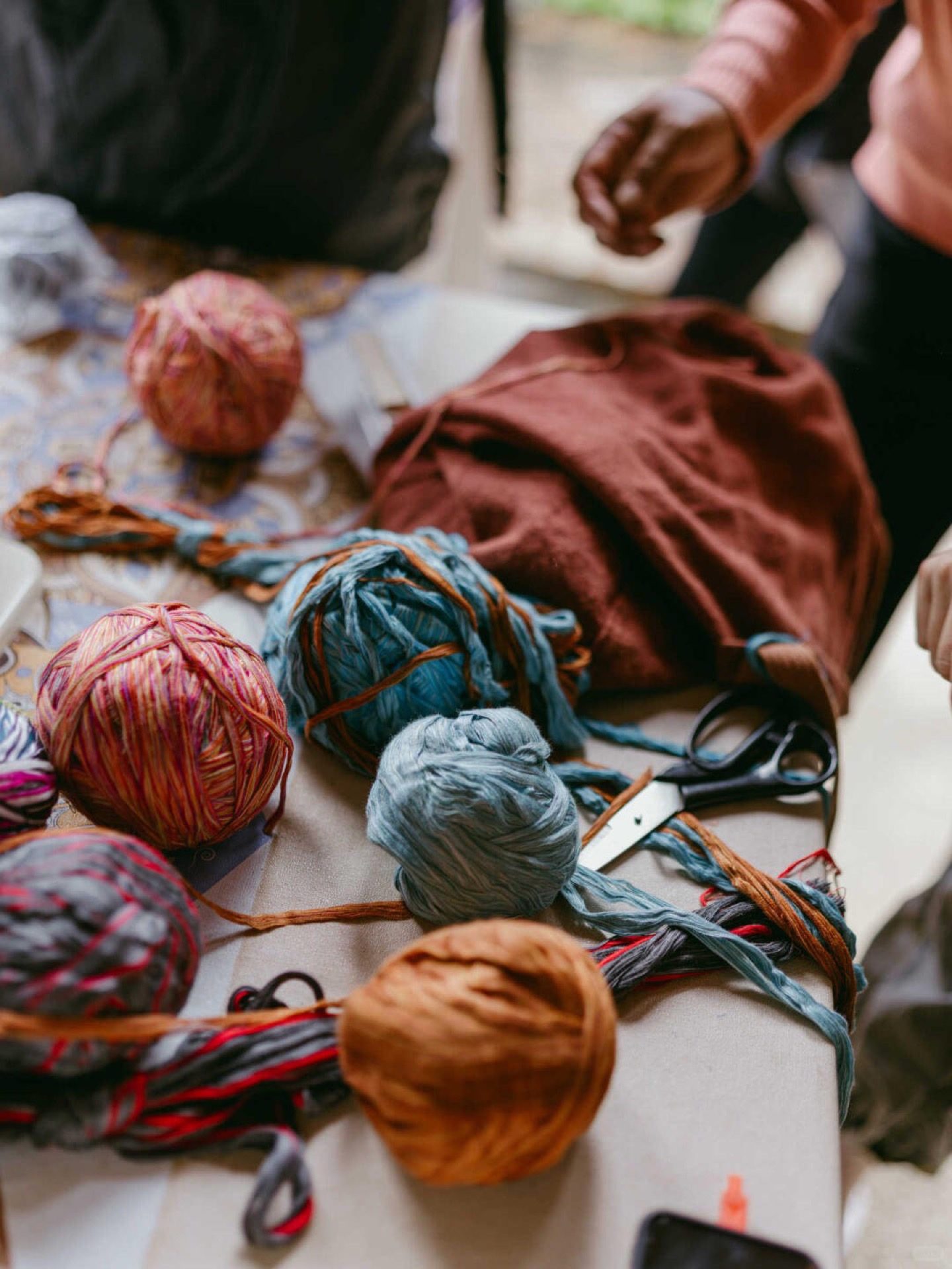 Moso woman weaving traditional textiles beside Lugu Lake