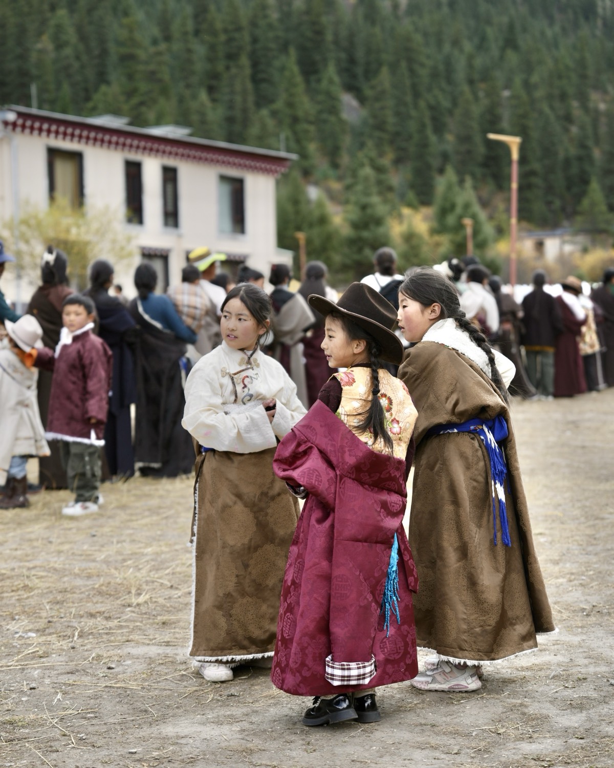 Young Tibetan children in traditional chuba robes at a West Sichuan festival