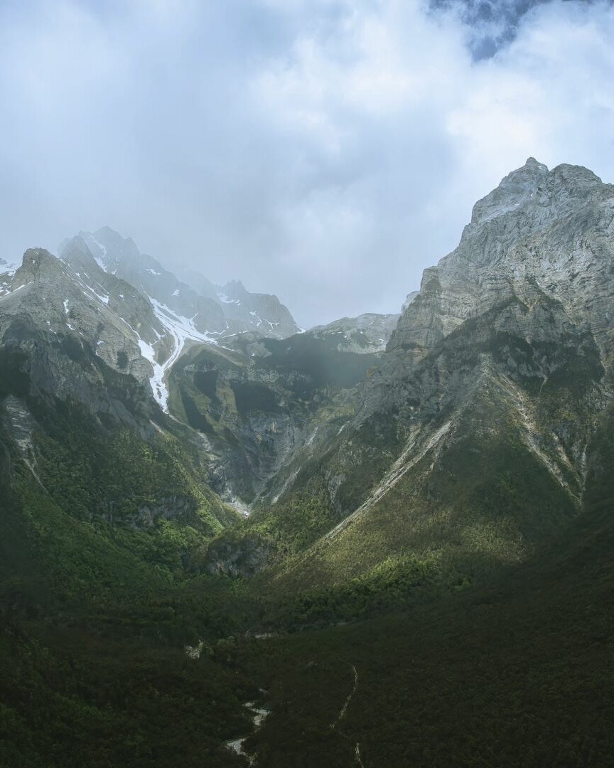 Moody granite peaks rising above a forested valley en route from Yading to Lijiang