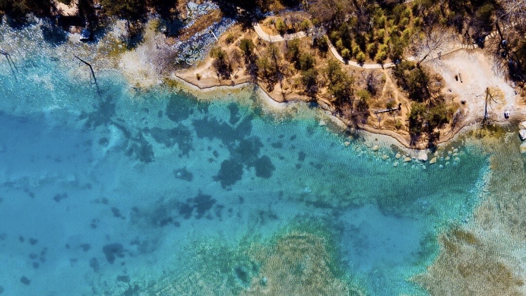 Aerial view of a turquoise alpine pool below Jade Dragon Snow Mountain