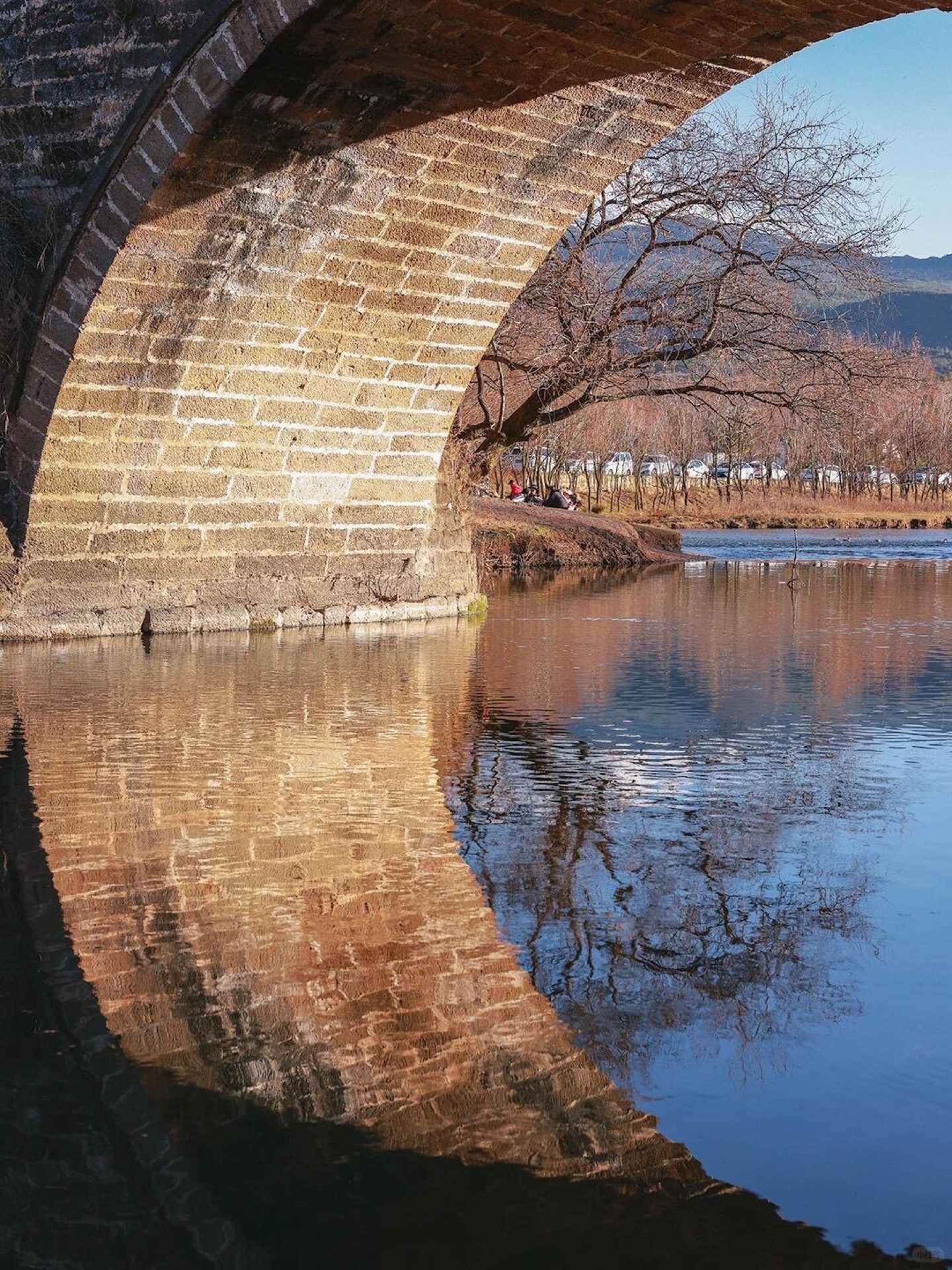 Ancient town gateway arch of Shaxi lit by morning sun — the restored caravan-era entrance used since the Tang dynasty