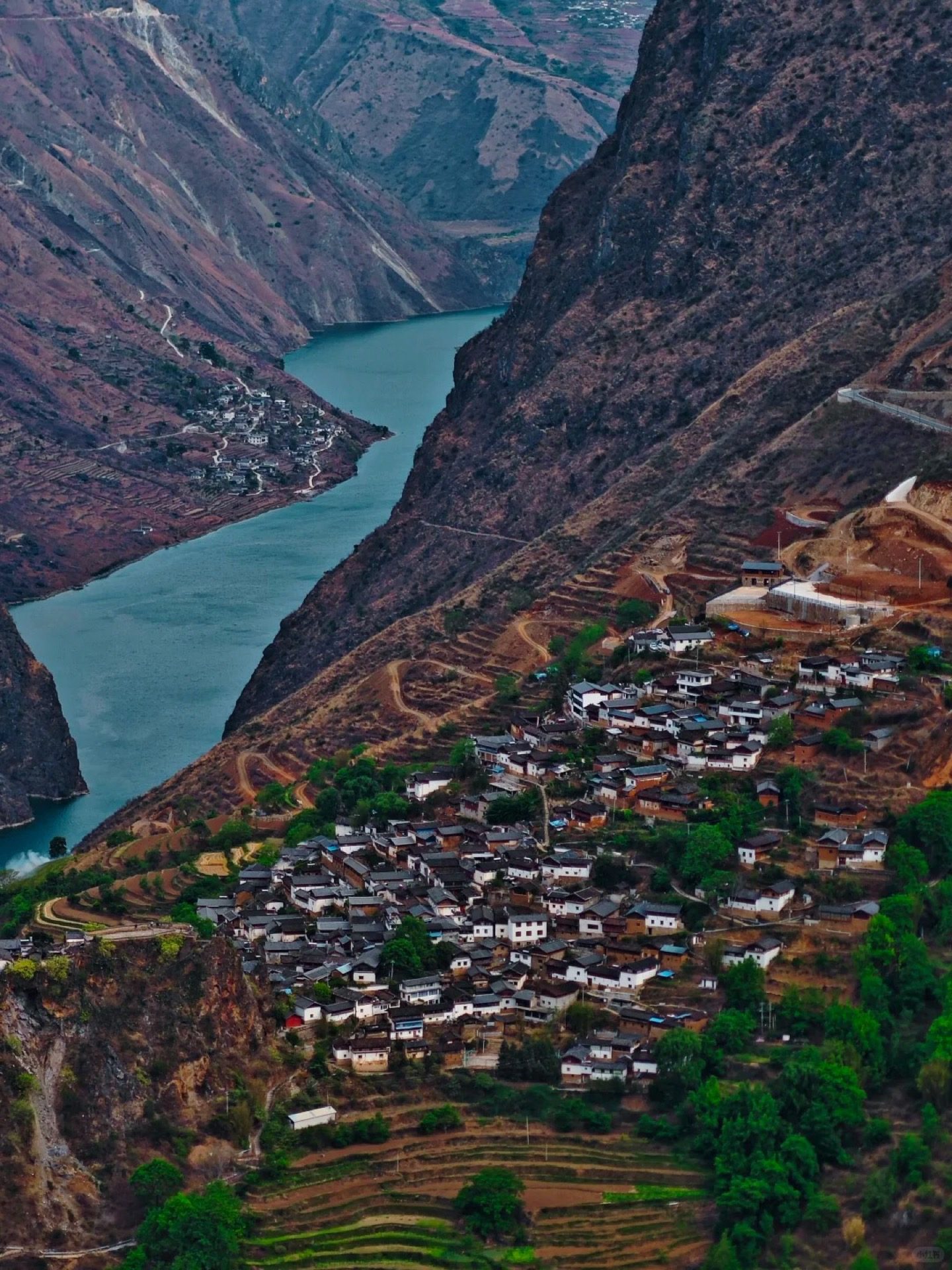 Baoshan Stone City village seen from above — ancient Naxi settlement perched on a rocky promontory in the Yunnan highlands