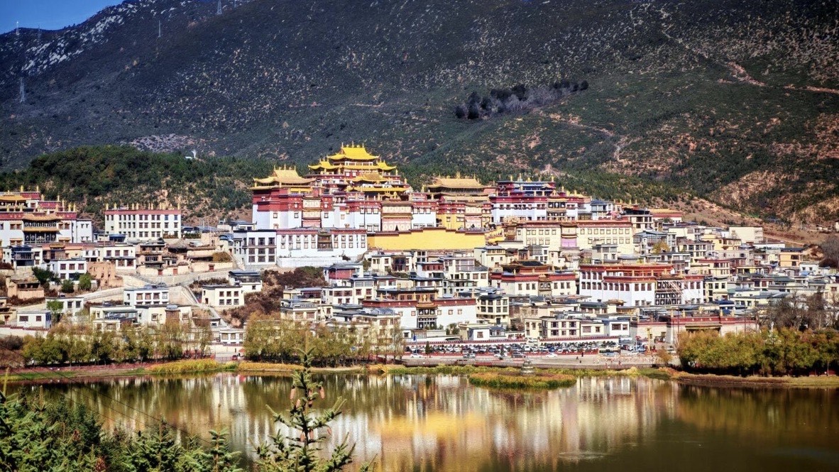Songzanlin Monastery on the hillside reflected in a mirror lake, Shangri-La