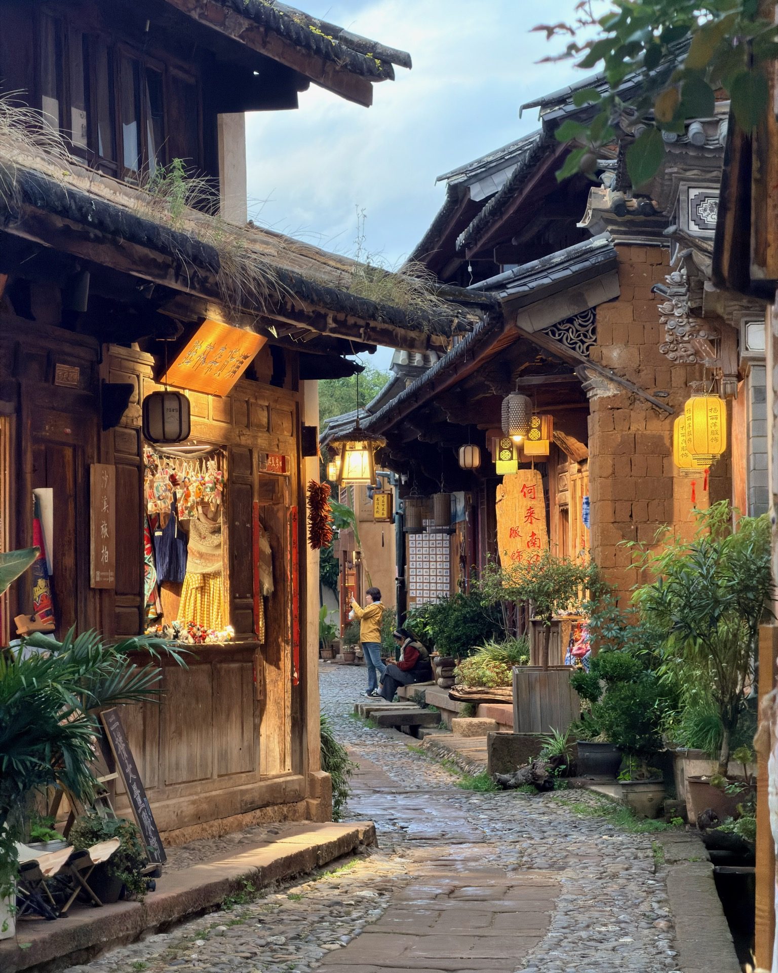 Lantern shop glowing in the evening along a narrow Shaxi alley — Yunnan slow culture tour