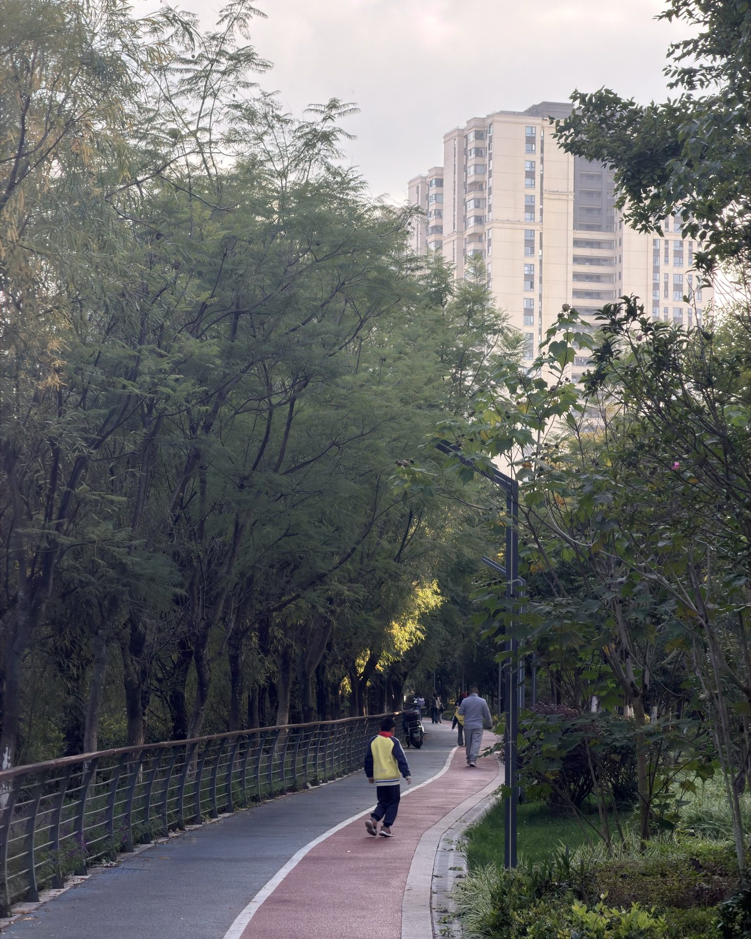Urban riverside path with greenery and city skyline reflections in Kunming — Yunnan slow culture tour