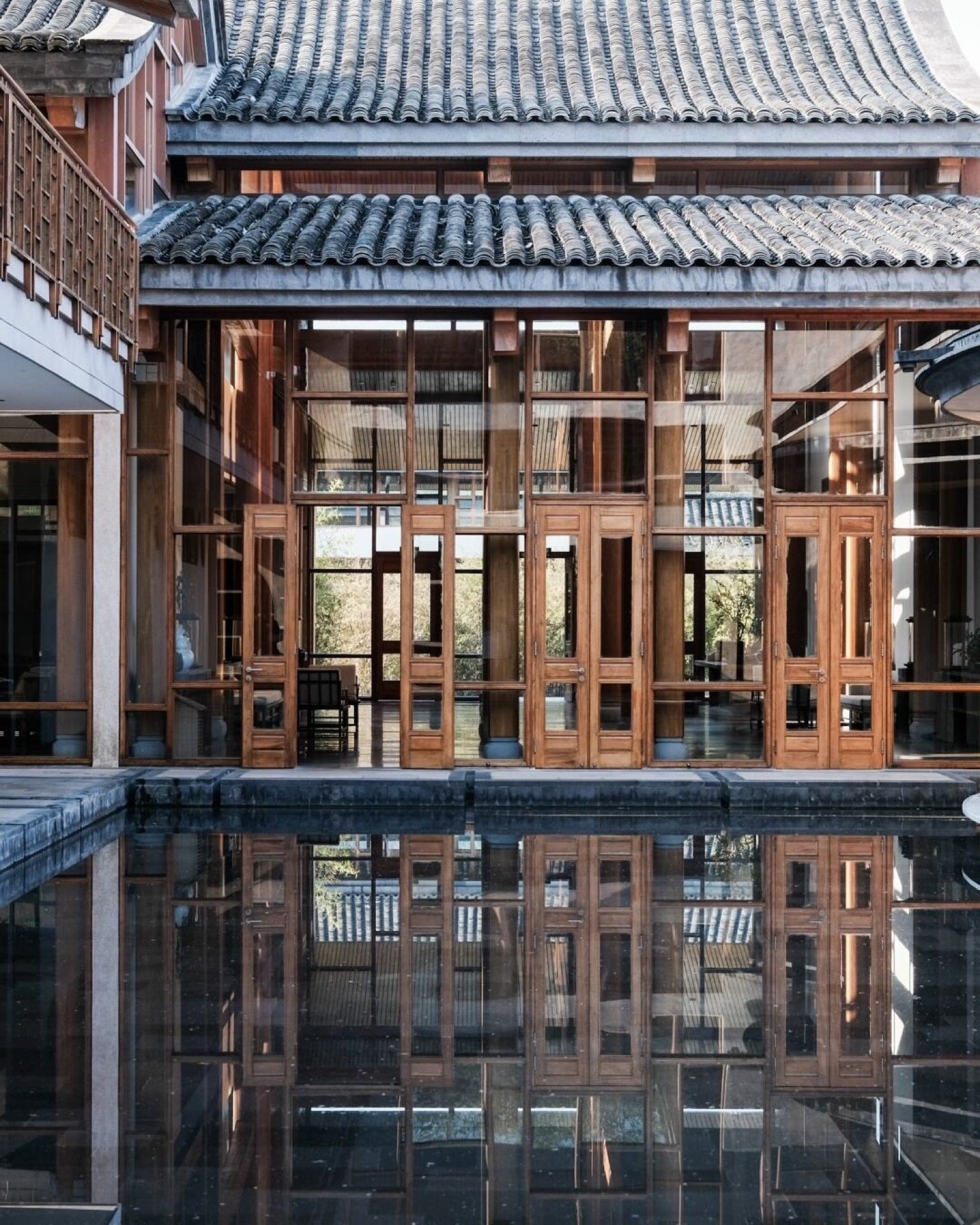 Courtyard garden of Bailian Heshun Hotel with stone paths and traditional eaves, Tengchong — Yunnan slow culture tour