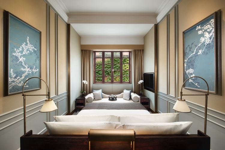 Capella Shanghai, Jian Ye Li — a villa bedroom between blue panels painted with blossom and birds, a daybed beneath a timber-framed window