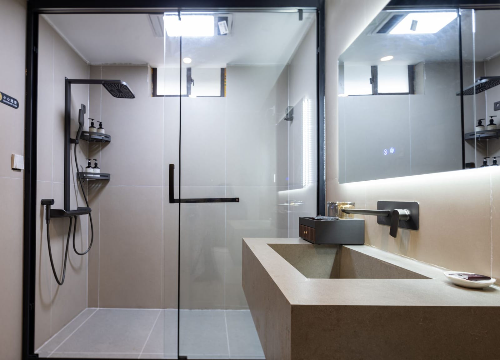 Jilin Mountain Lodge — a bathroom in grey stone with a walk-in rain shower and a stone basin