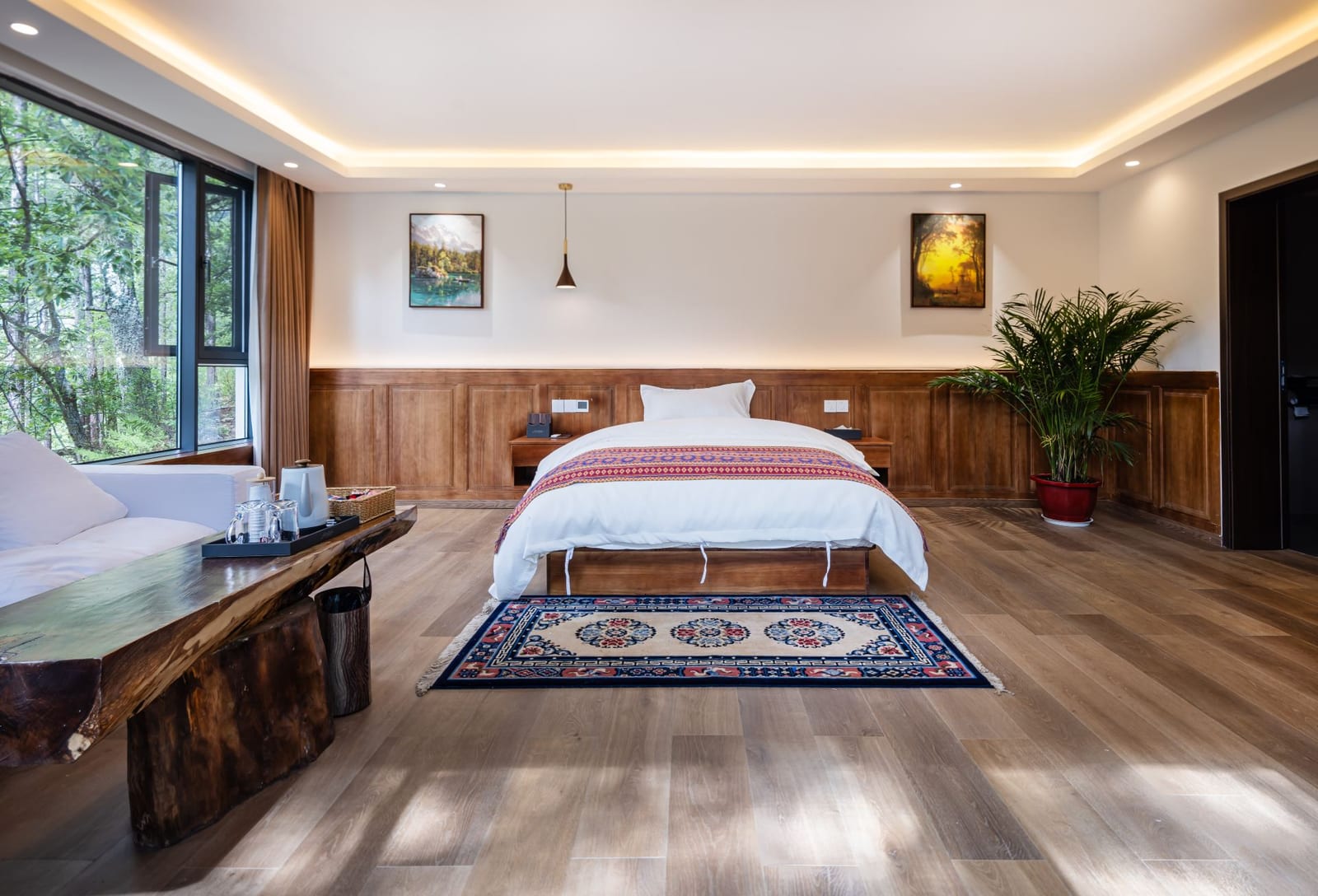 Jilin Mountain Lodge — a bedroom with timber floors, a Tibetan rug and a picture window
